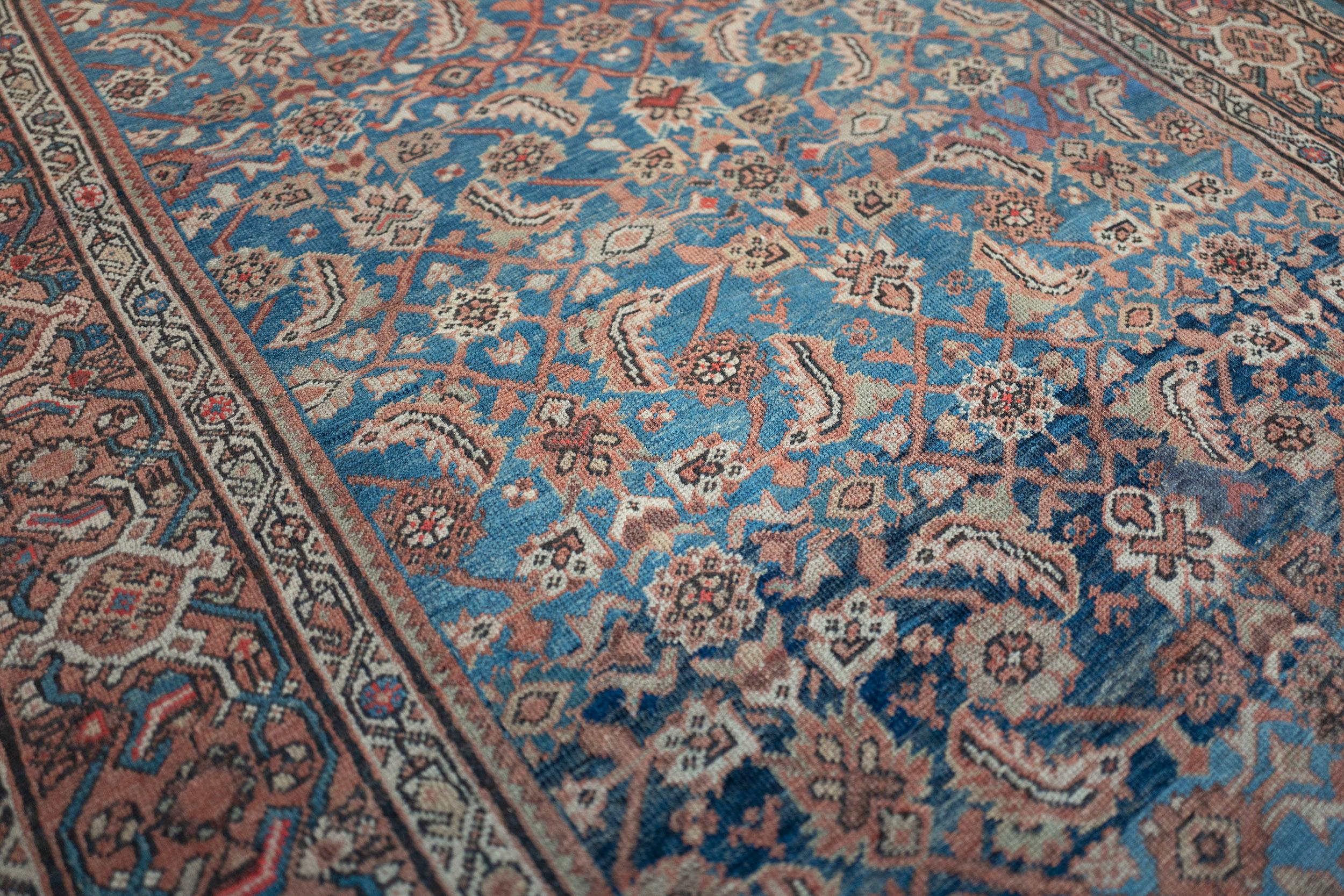 This traditional handwoven Persian Sultanabad rug has a shaded lake blue field with overall herati pattern, in a shaded apricot interlocking turtle palmette border, between delicate ivory paisley stripes.

The city of Sultanabad (now known as Arak)