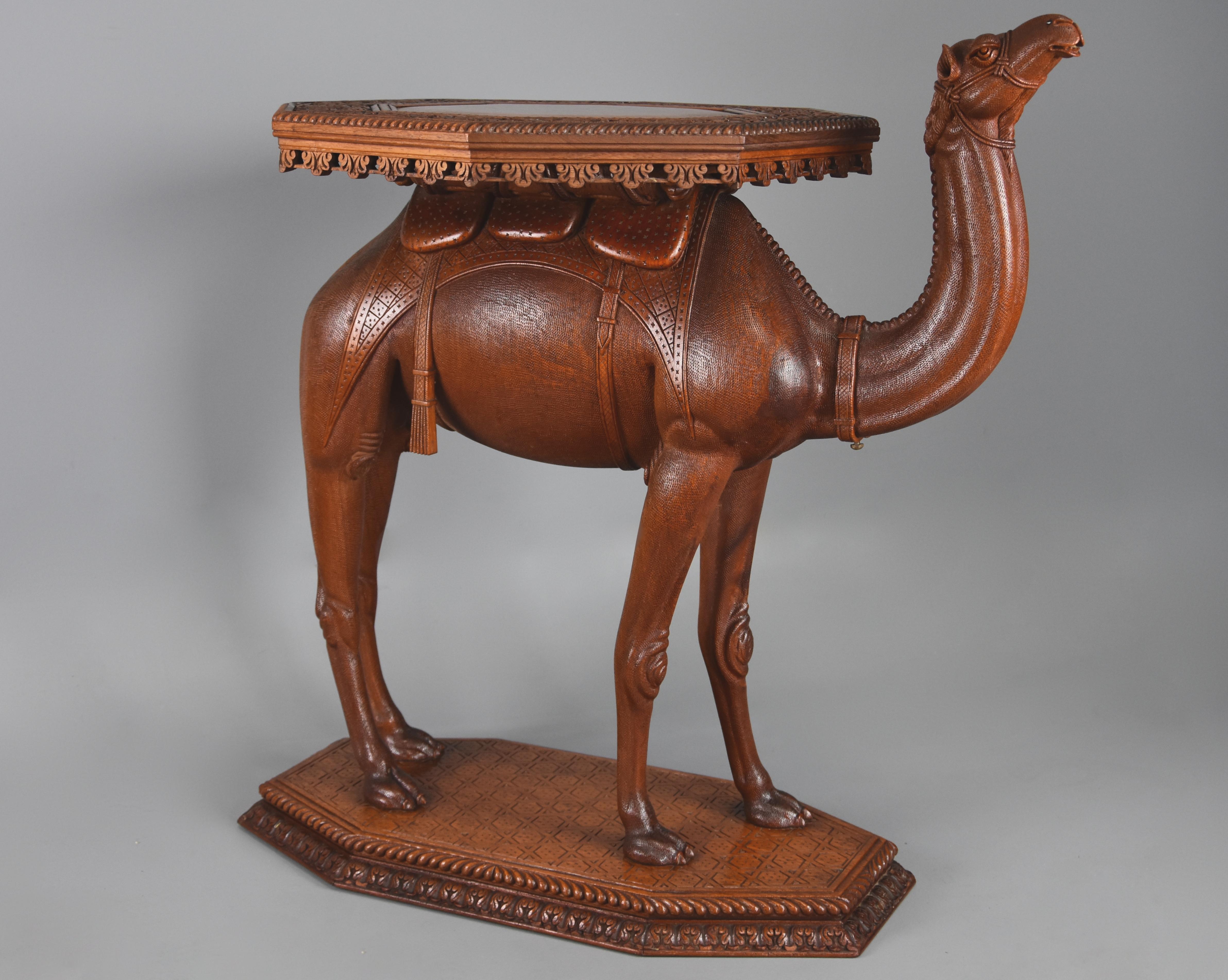 A late 19th-early 20th century Anglo Indian hardwood camel table of superb quality, possibly from the Gujarat region of India. 

The table consists of an octagonal top with plain central section surrounding by a profusely carved floral and foliate