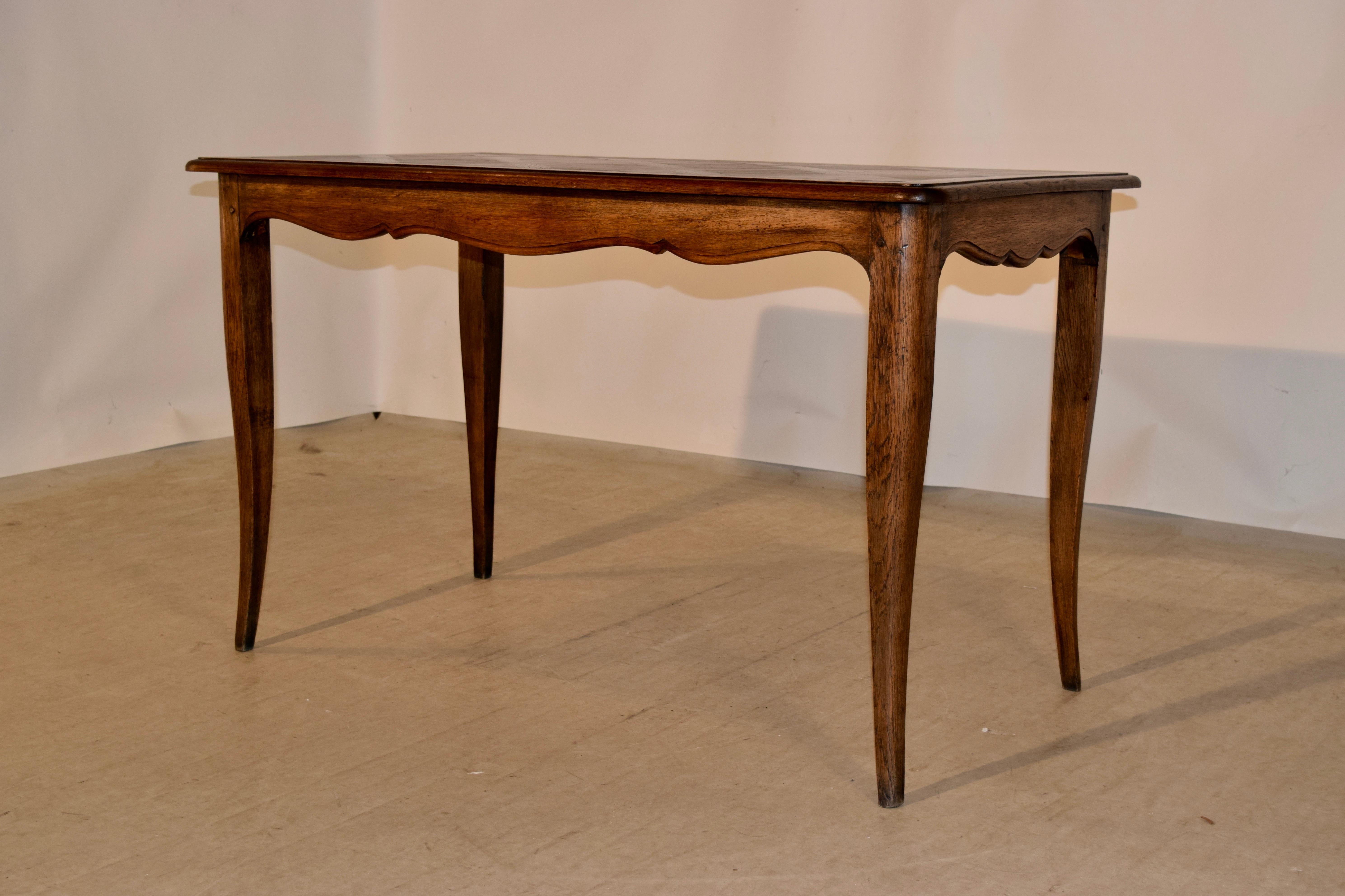 Late 19th century table with a lovely banded and bevelled edge surrounding a parquetry central panel. The apron is scalloped and has a bevelled edge and the table is supported on splayed cabriole legs. The apron measures 25 inches in height.