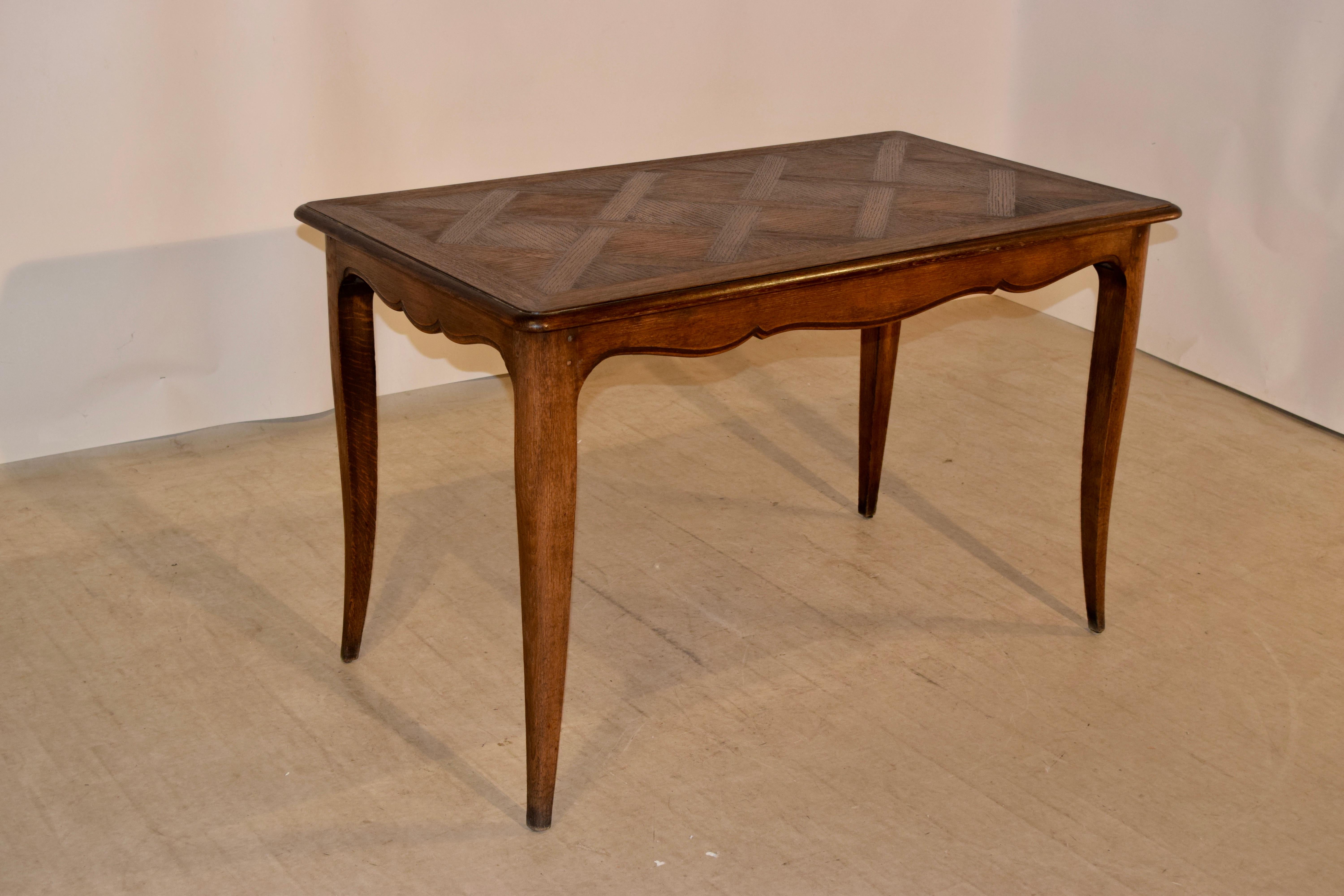 Late 19th century table with a lovely banded and bevelled edge surrounding a parquetry central panel. The apron is scalloped and has a bevelled edge and the table is supported on splayed cabriole legs. The apron measures 25.25 inches in height.