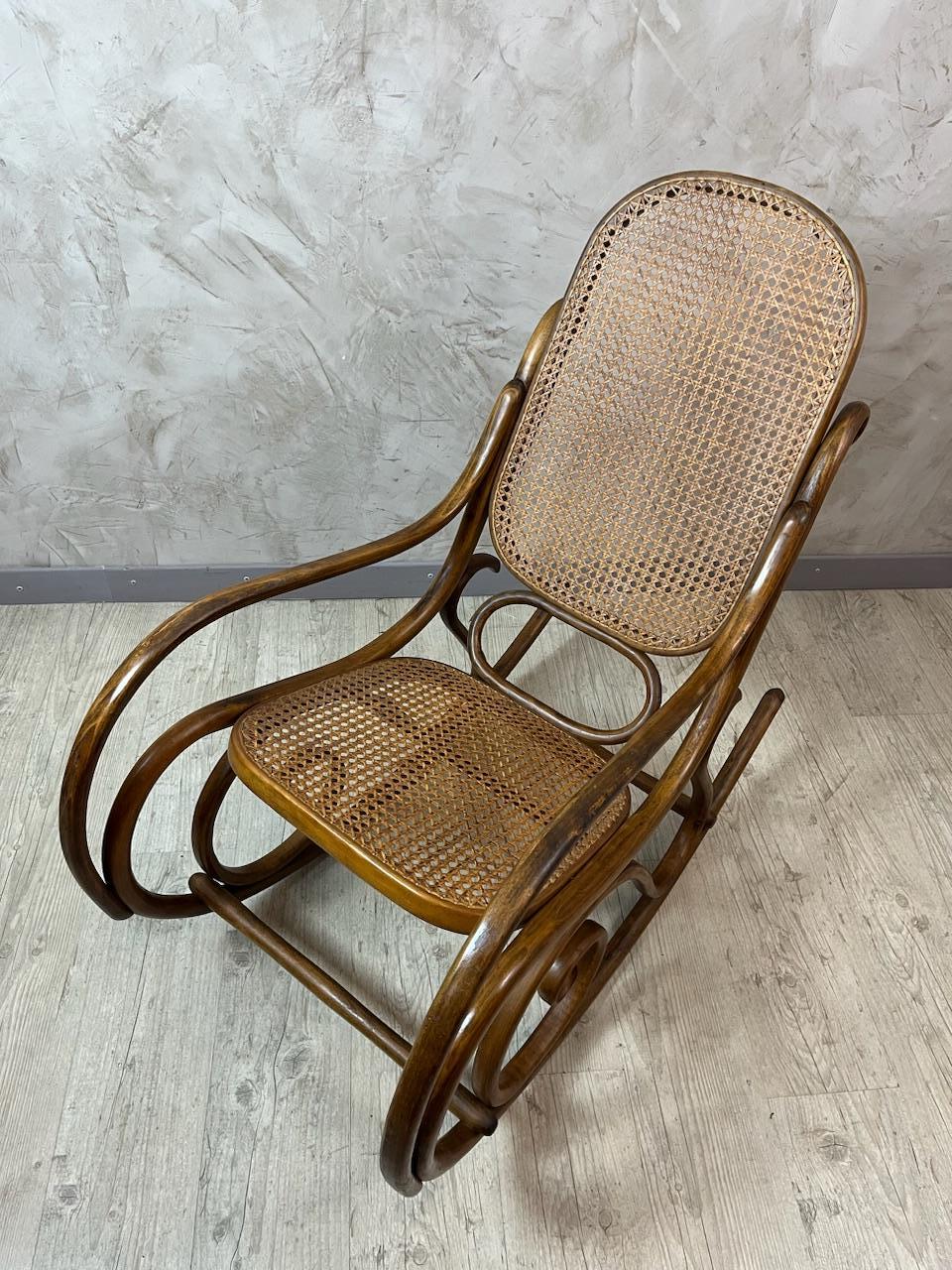 Porta charme ed eleganza ai tuoi interni con questa splendida sedia a dondolo Thonet, un pezzo iconico del design viennese del XIX secolo.
Si tratta di un modello autentico realizzato in legno curvato, caratterizzato da curve aggraziate e da una