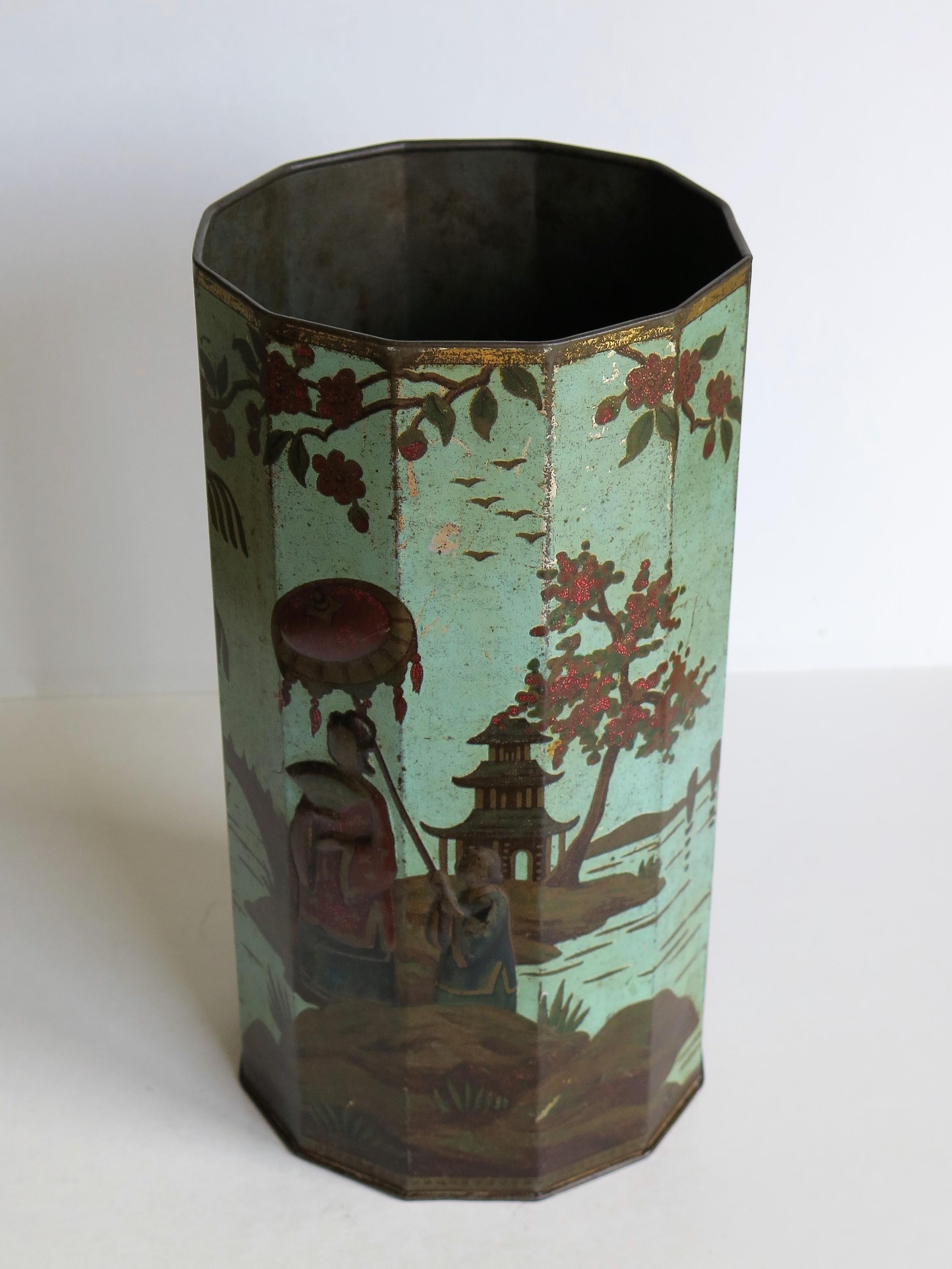 This is a very decorative tin bin or container with a colored scene of oriental figures which we date to the late 19th or early 20th century. It has many possible uses in the home as a small waste bin, a vase for dried flowers or simply displayed as