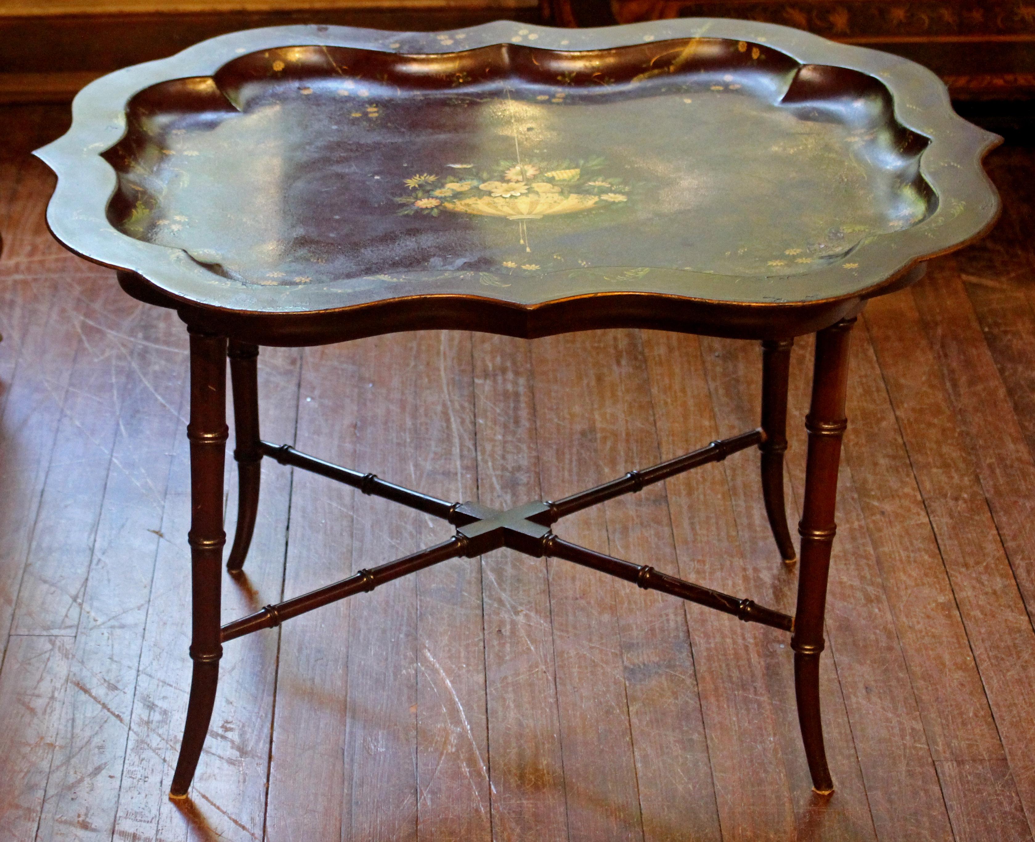 An elegant tole mulberry colored tray on custom made faux bamboo coffee table height stand. Decorated with hanging basket of flowers, scrolling gilt and floral boarders. 31 5/8