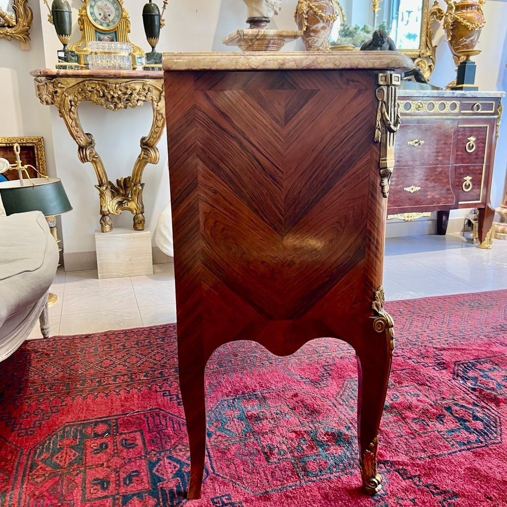 We present a rare and sophisticated Louis XV transition style commode comprising two doors adorned with vivid scenes of life in Chinese lacquer and marquetry. The remaining structure of the dresser is crafted from aged grey rosewood, elegantly