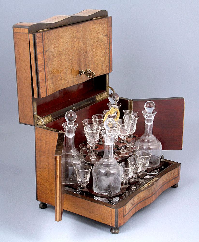 Late 19th century travel mahogany canteen with a set of glasses for liqueurs.
4 decanters with slender necks, turned up spout and stoppers. Decorated and polished on the bellies. In addition, 16 glasses on a slender stem are similarly decorated.