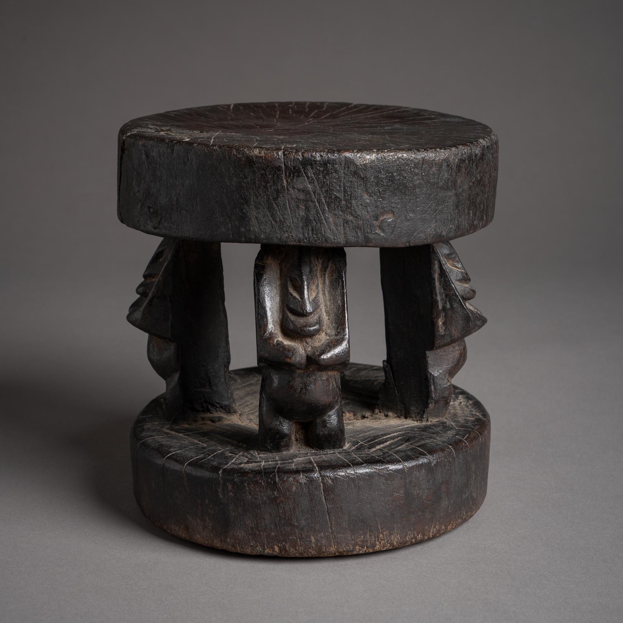 Stout, strong proportions and a dark patina give this figural stool a powerful sculptural presence. In contrast with the elongated, more naturalistic body forms found in the most detailed Dogon stools, the figures here are more abstract and compact,