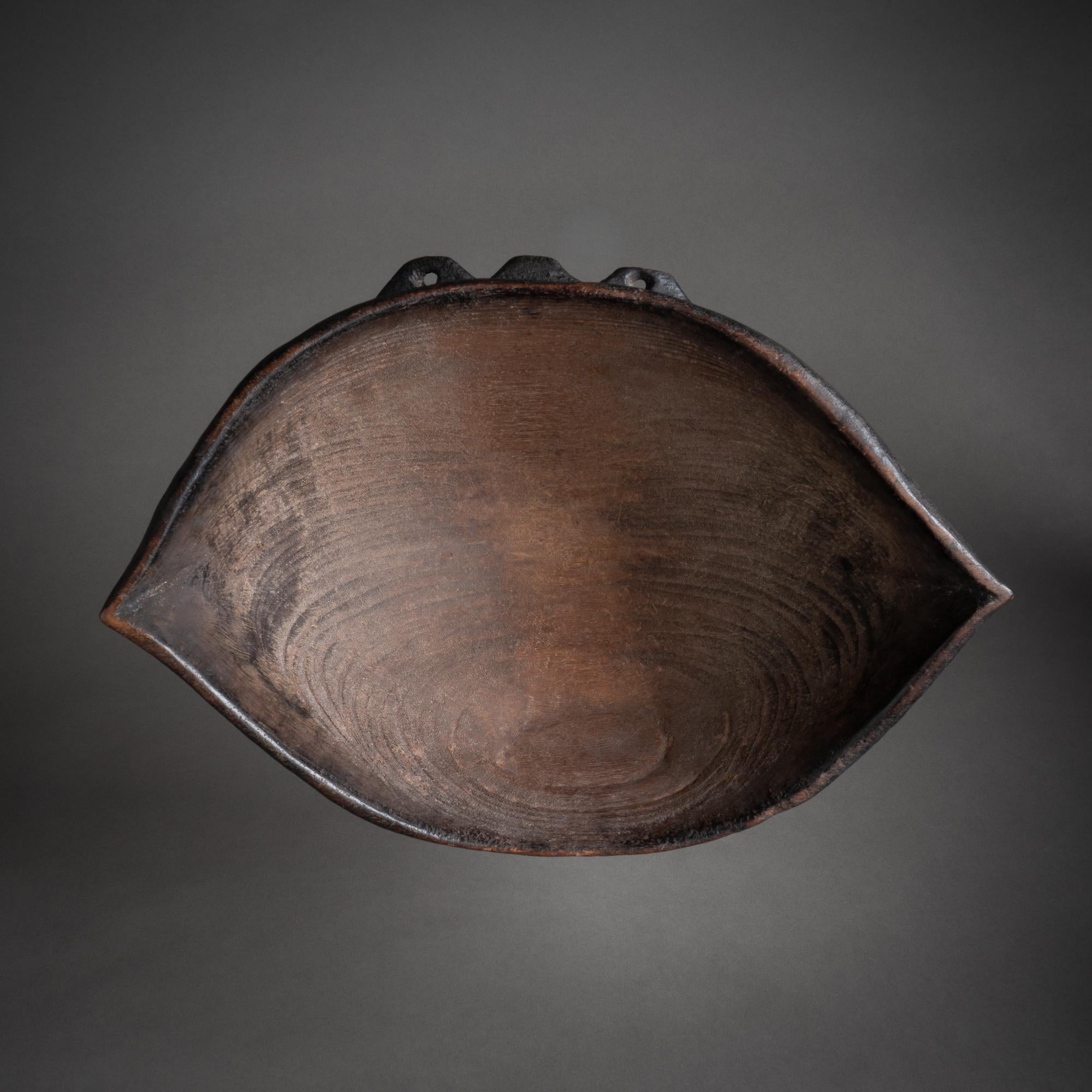 A beautiful wooden bowl in the Classic almond-shaped style of the Lumi, who are located in the heart of the Sandaun Province of the northwestern corner of Papua New Guinea. When not in use, a bowl such as this would be hung from the wall by its