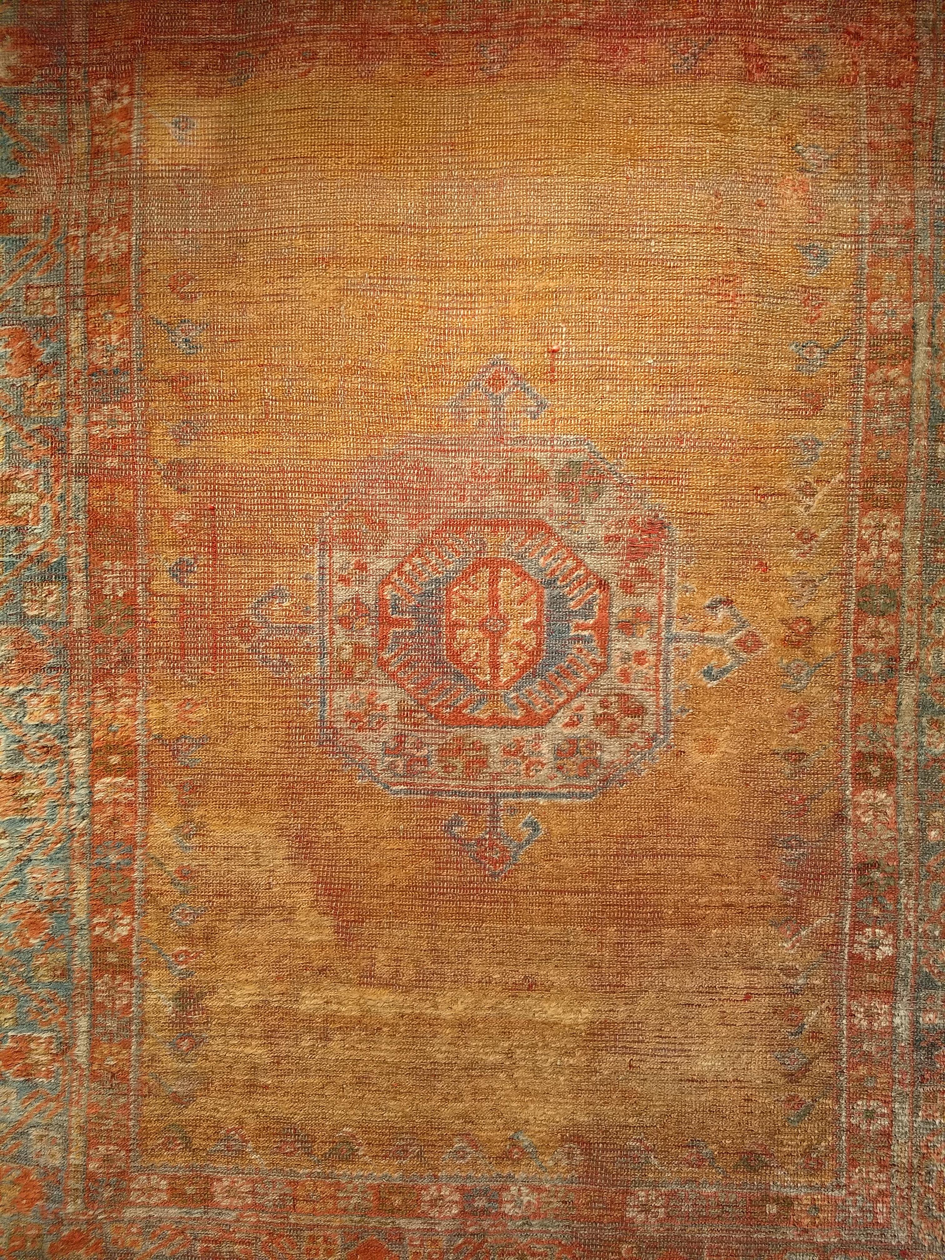 A Turkish Oushak area rug  from the 3rd quarter of the 1800s.  The rug has the classic design of the Mamluk rugs from the 15th and 16th centuries.   The rug has a beautiful saffron yellow field. It has a small central medallion in blue/green and