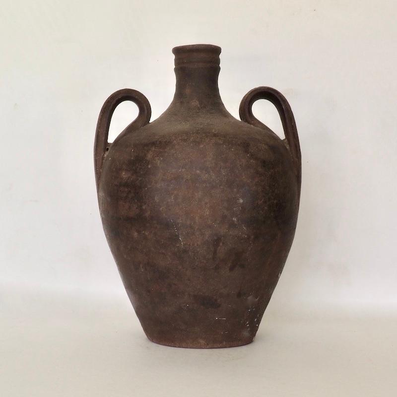 A double handled antique Portuguese stoneware jug. Late 19th century. The jug has one flattened side for it to be stored on its laying down. Jugs such as these were used throughout Iberia for water, oil and wine and found their way to the Americas