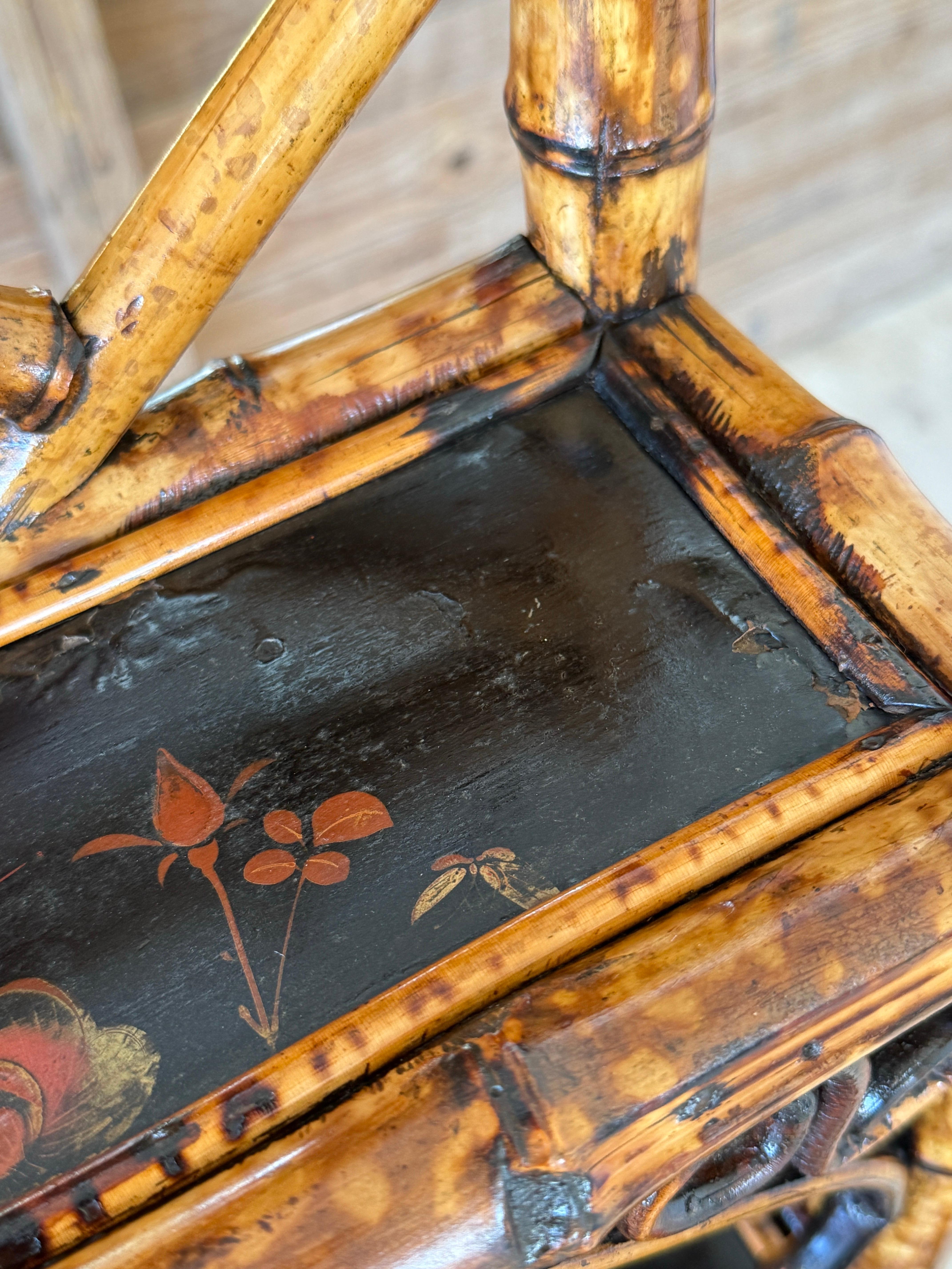 Etagère in bambù dell'Aesthetic Movement vittoriano della fine del XIX secolo, con ripiani laccati e dipinti a mano con motivi floreali e uccelli.
La struttura in bambù è stata completamente restaurata e rifinita, conservando la sua ricca patina e