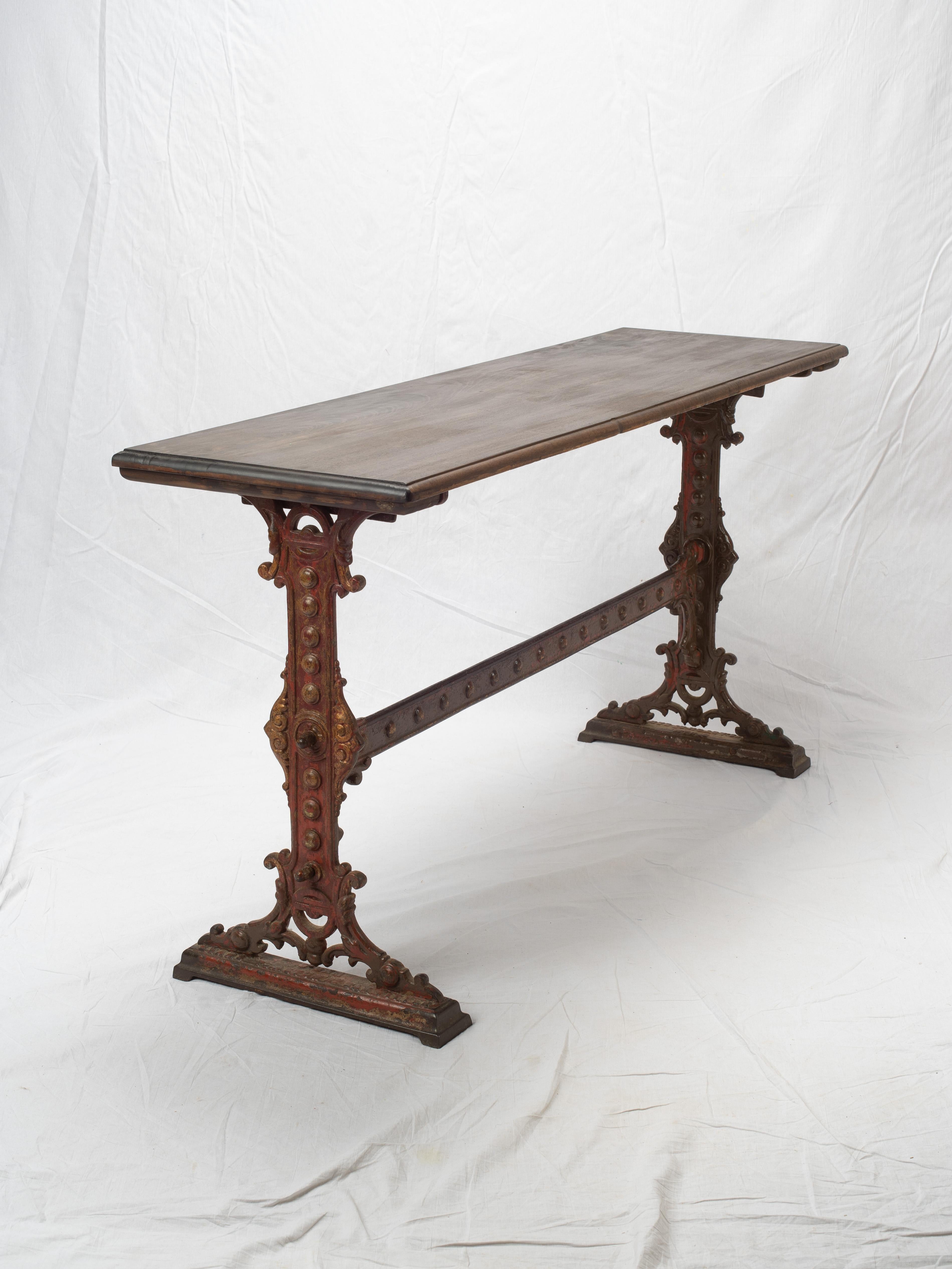 Old English pub tavern table made of cast iron with beautiful patina. Replacement pine table top currently in place.

Good Condition. Rustic tabletop that has imperfections. Expect nicks, dings, scratches and evidence of the handmade. Base has been