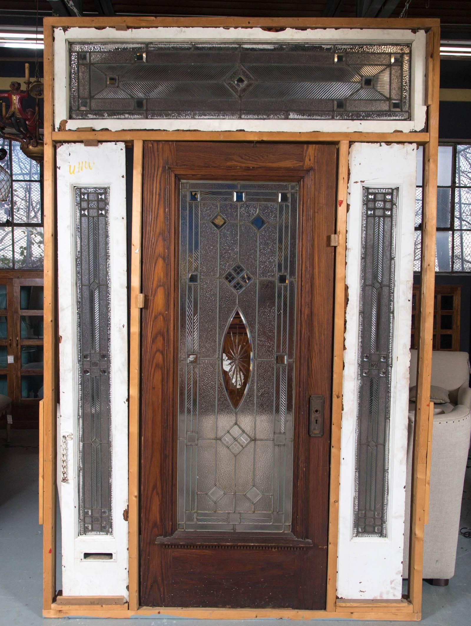 Late 19th century Victorian entranceway unit consisting of leaded glass door an 2 leaded glass sidelights and leaded glass transom. Door has 1 tiny crack but secure. 1 sidelight has 2 minor cracks but secure. Door is 34