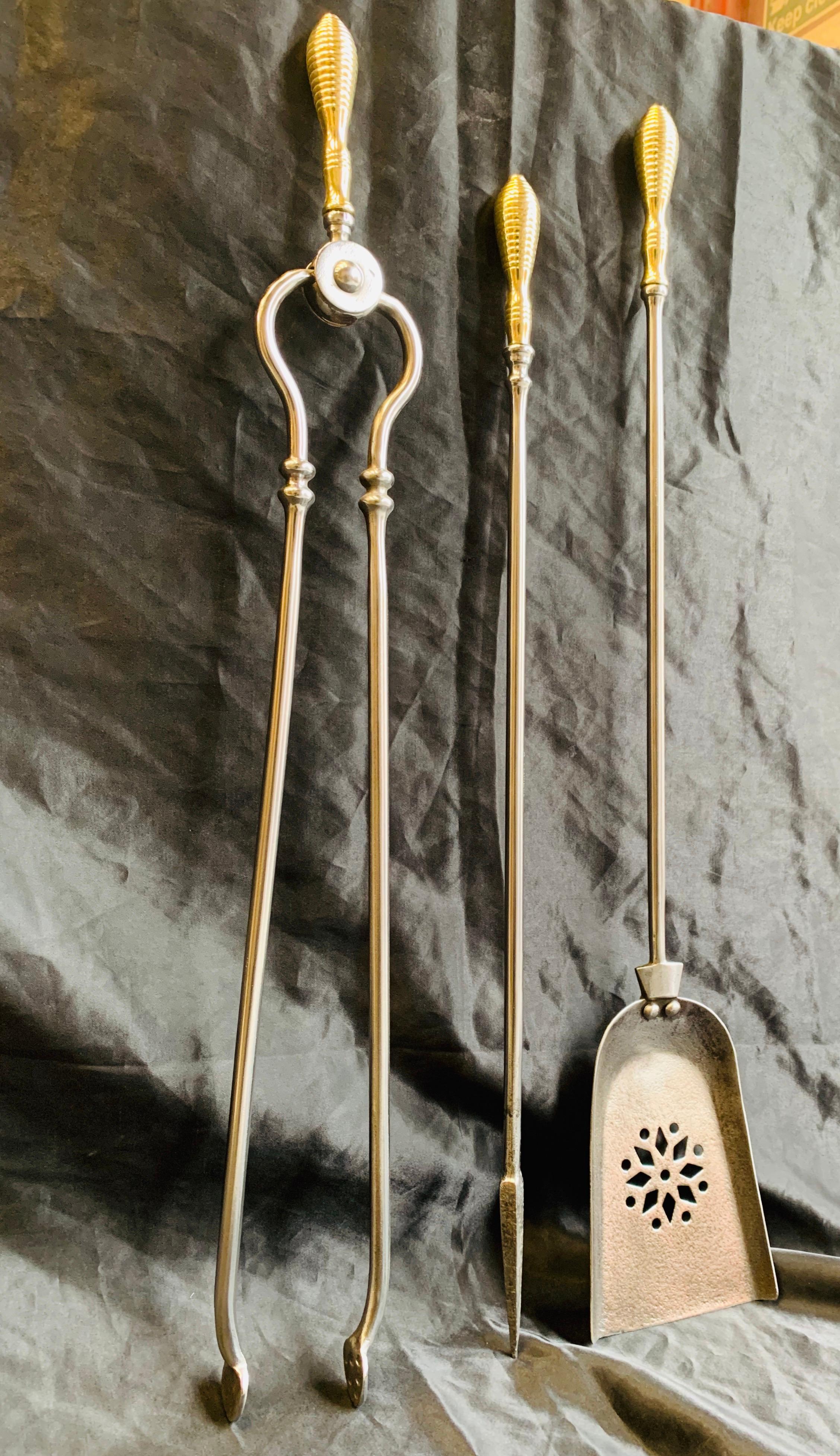 A simple set of late 19th century Victorian fire tools with attractive polished brass beehive handles and polished steel shafts, comprising of a poker, shovel with pierced blade and tongs.

English, circa 1900.