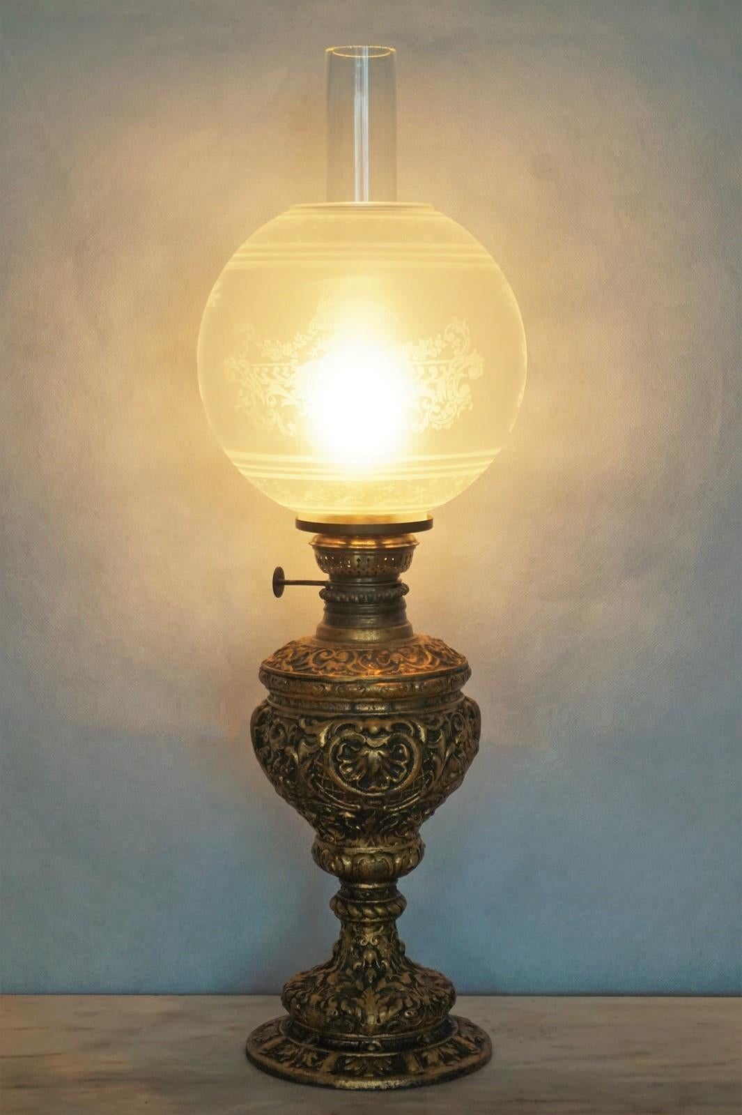 Victorian style heavy cast gilt bronze oil lamp converted to electric table lamp, etched glass globe and clear glass chimney, France, 1880-1890. This oil lamp has been converted to electric in the 1930s.
One E14 light bulb socket.
Measures: Height