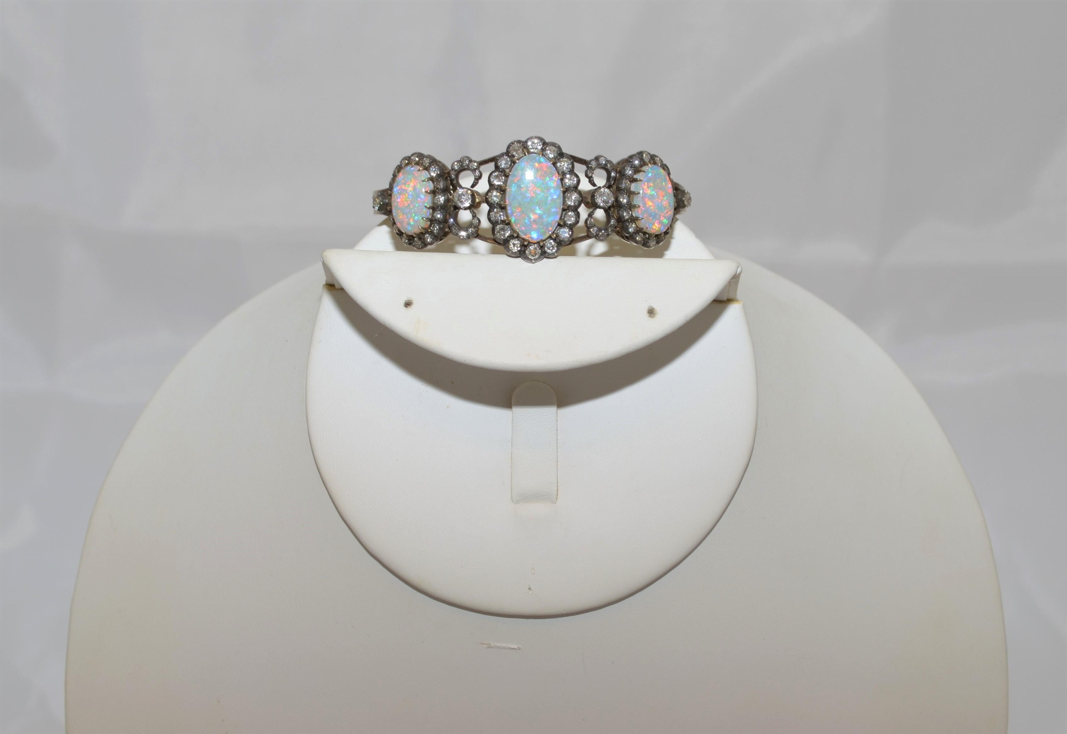 Late Victorian era (late 19th century-early 20th century), gold, silver, diamond and opal bracelet. Bracelet features 3 large AAA white cabochan cut opals that measure 16mm x 10mm x 3mm and two 13mm x 10mm x 3mm with estimated carat weight of 4.78