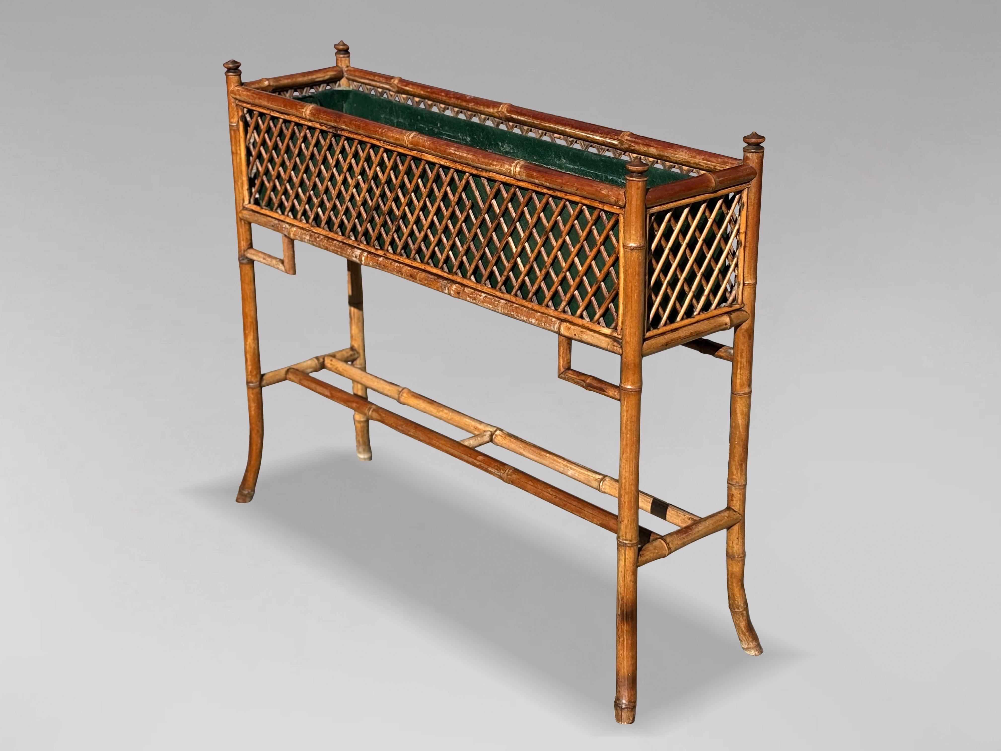 A very elegant late 19th-century Victorian freestanding rectangular bamboo jardinière, featuring cross-woven rattan panels and raised on swept legs joined by crossed stretchers. It includes the original removable green-painted metal liner. The