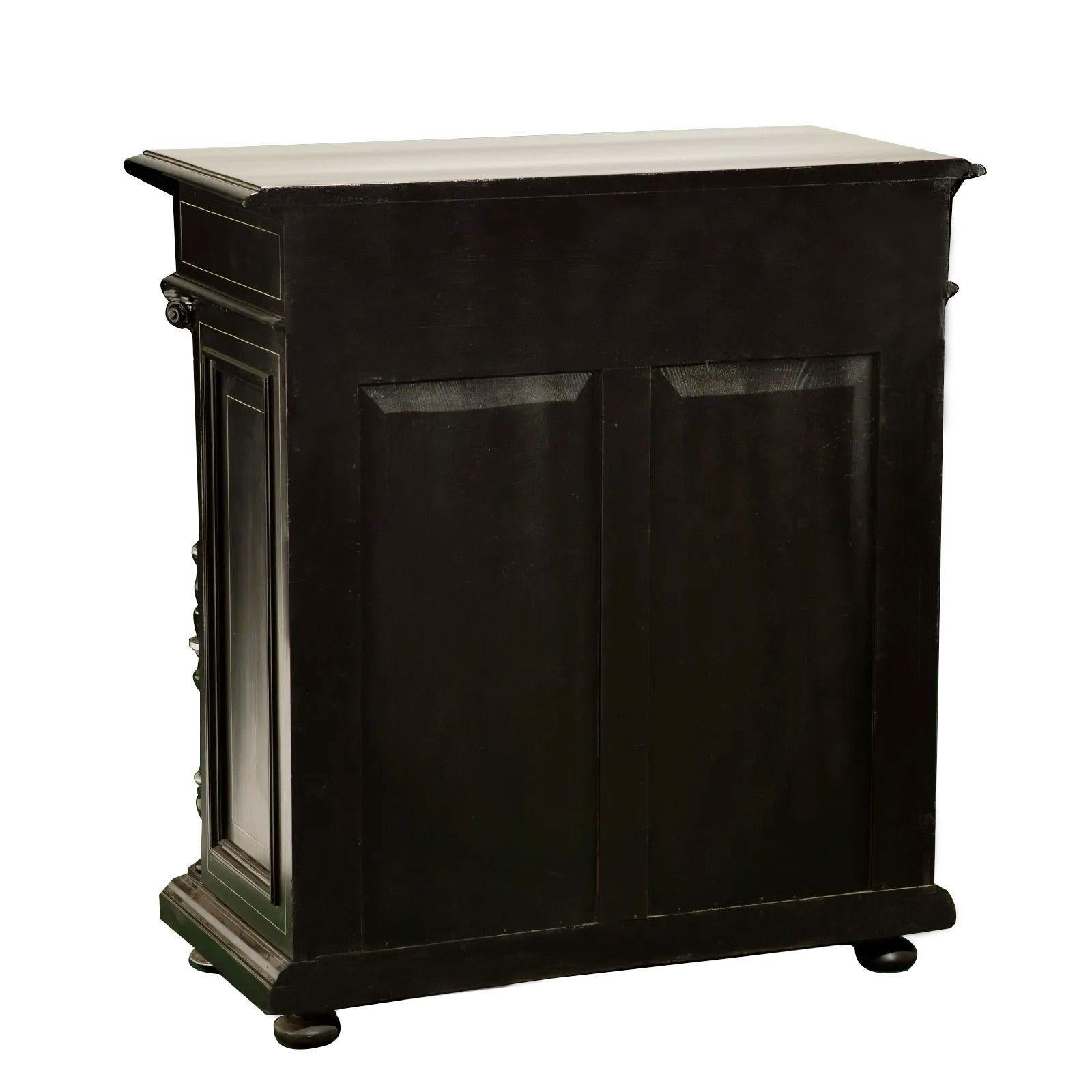 Victorian Renaissance Revival cabinet, Late 19th century

The ebonized body with bone inlay of figural winged angels and motifs of nature, two upper drawers, and a double-door cabinet flanked by Corinthian columns on bun feet
