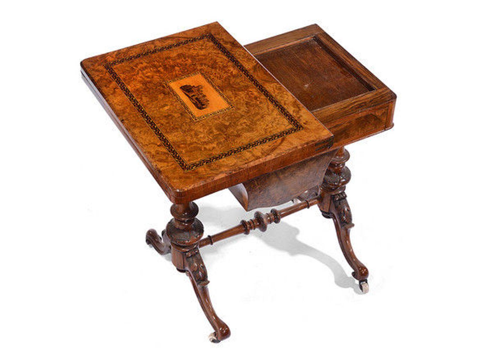 A late 19th century Victorian walnut and inlaid games and work table.

The burr walnut top, with a central inset Tunbridge ware plaque depicting a cathedral surrounded by ebony and satinwood banding and with a folding swivel top that opens out to