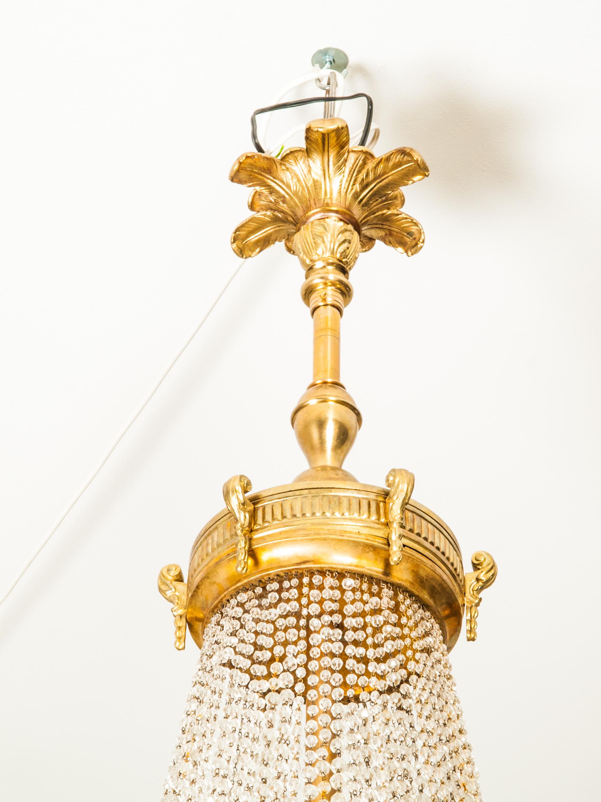 Antique Viennese gilt bronze six-light chandelier ormolu frame decorated with flower garland.
All arms in shape of flower buds carry bulbs. Basket is surrounded with suspended chains of graduated handcut crystal pearls inside the basket are six