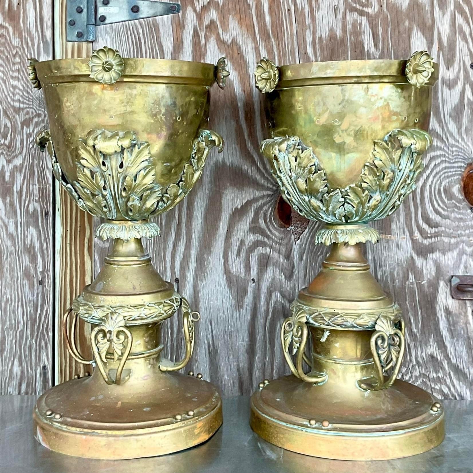 Aggiungi un tocco di eleganza al tuo arredamento con questa coppia di urne con piede in ottone neo-classico vintage. Queste urne in stile americano sono caratterizzate da dettagli intricati e da un design senza tempo, perfette per esporre