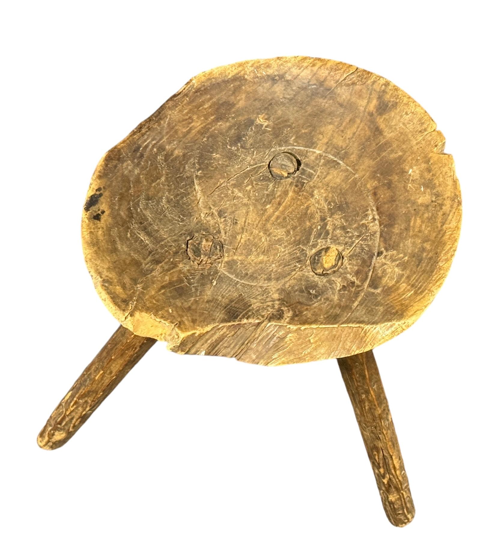Ce tabouret de traite autrichien à trois pieds de style wabi sabi de la fin du XIXe siècle est un excellent exemple de ce style. Le meuble est doté d'une assise carrée en bois d'aspect rustique et repose sur trois pieds. Le tabouret présente un