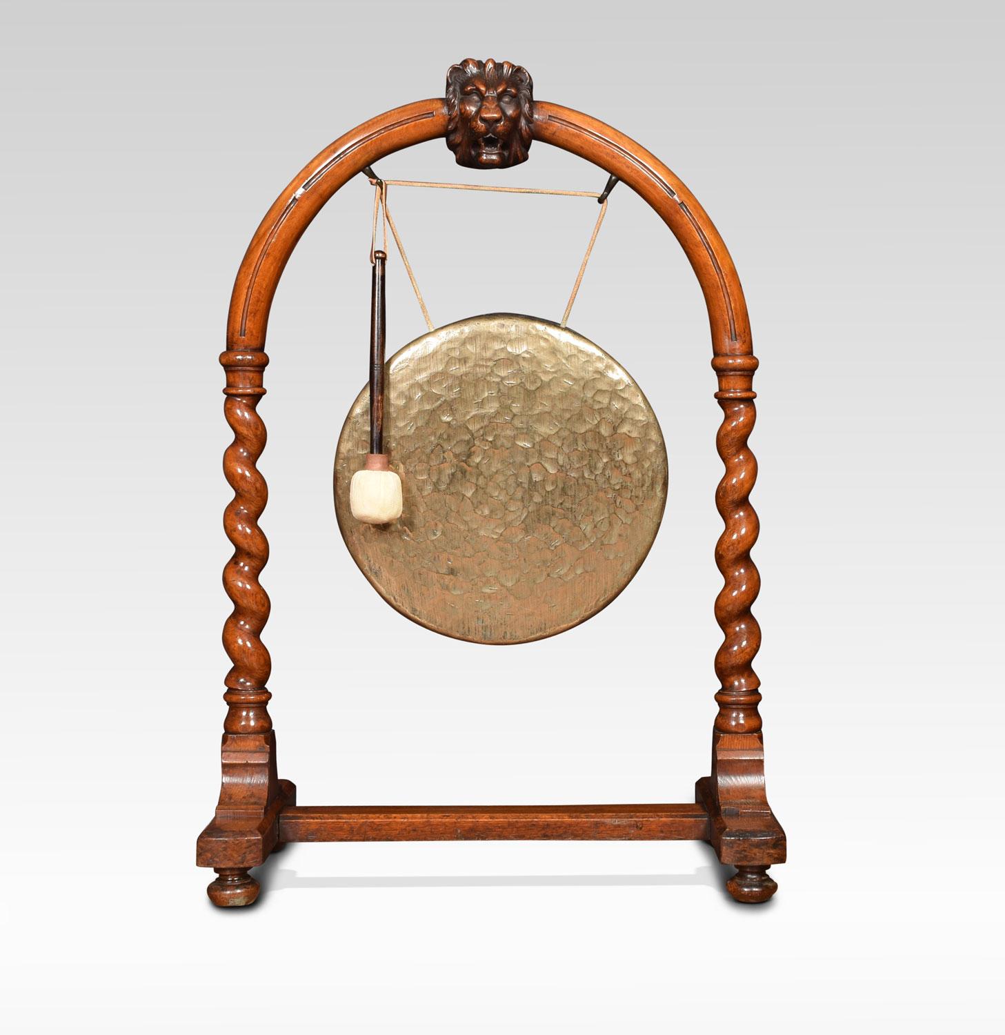 19th century walnut dinner gong and beater. The arched top with carved lion’s mask above barley twist supports. Having suspended brass gong to centre. All raised up on trestle base terminating in bun feet.
Dimensions
Height 41 Inches
Width 27.5