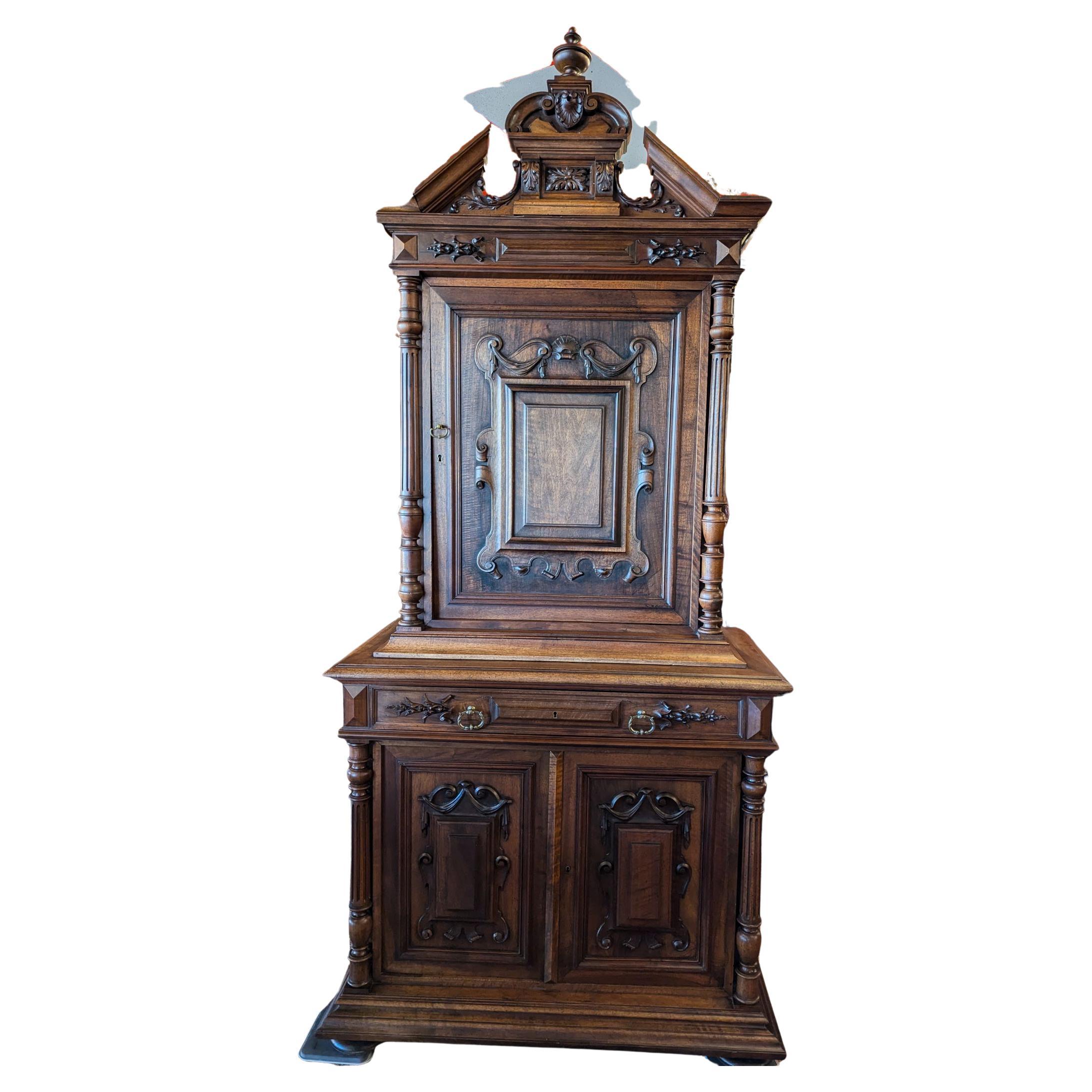 Este armario de caza de nogal alemán lo tiene todo, dos puertas inferiores con estante interior, cajón central, puerta del armario superior con dos estantes,  todas las tallas y columnas completas con cresta y remate central.  sin roturas, sin