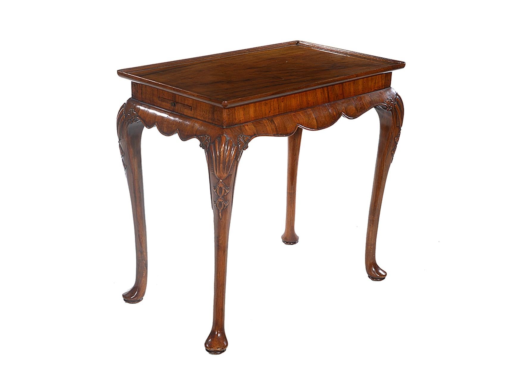A 19th century walnut sliver table, the dished top with a wrap around scalloped skirt and to each side, a pull out slide.

The cabriole legs, with shell and bell flower carving to the knees, end on pad feet.