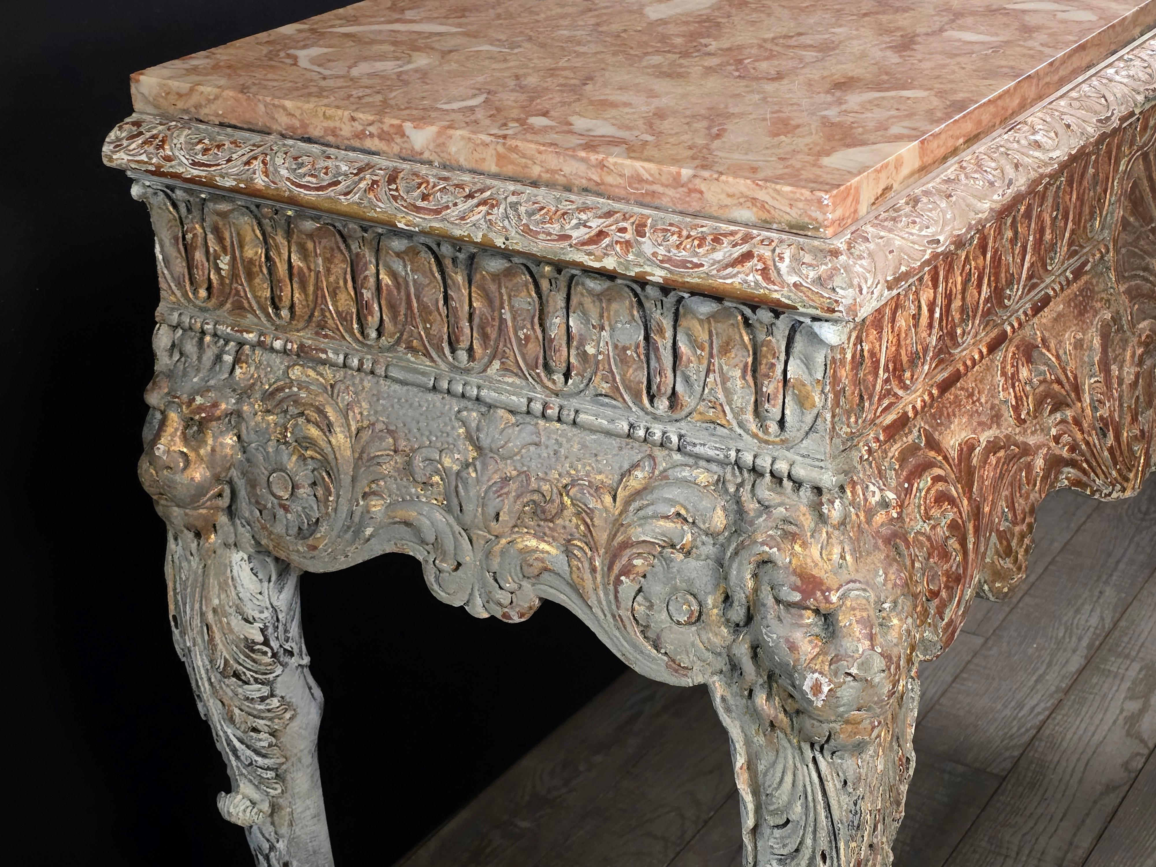 Consolle in legno dorato irlandese riccamente intagliato alla fine del XIX secolo in stile Kent Kent, con fregio centrato da una scenografica conchiglia smerlata, affiancata da maschere d'acanto e leone a scorrimento, sollevata da audaci gambe a