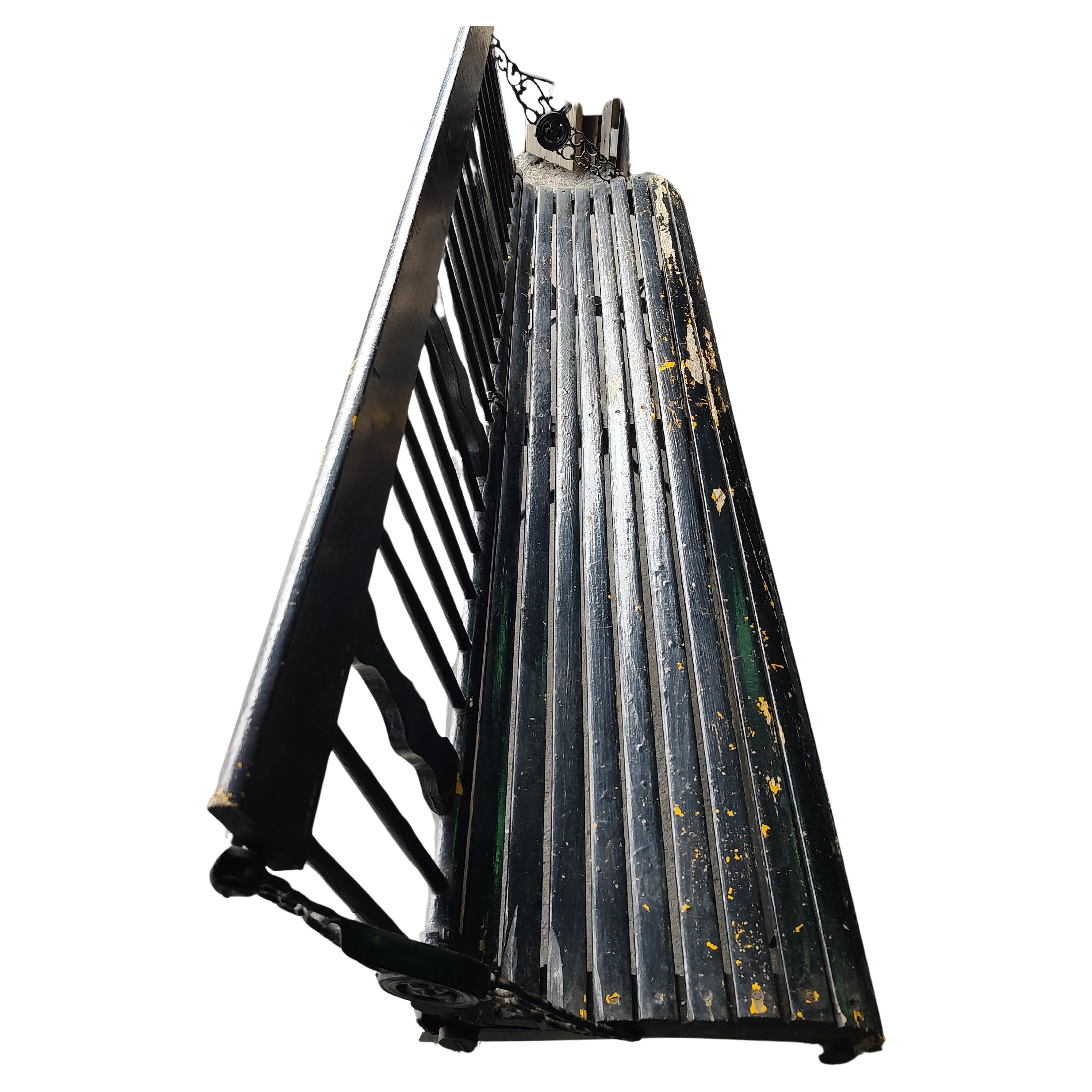 Fabulous mechanical Foldup long train station bench. Backrest folds down for transport and or storage. Black paint over old yellow makes for a great patina. Spindle back with slatted seat rests. Iron locking mechanism on each side. Strong and