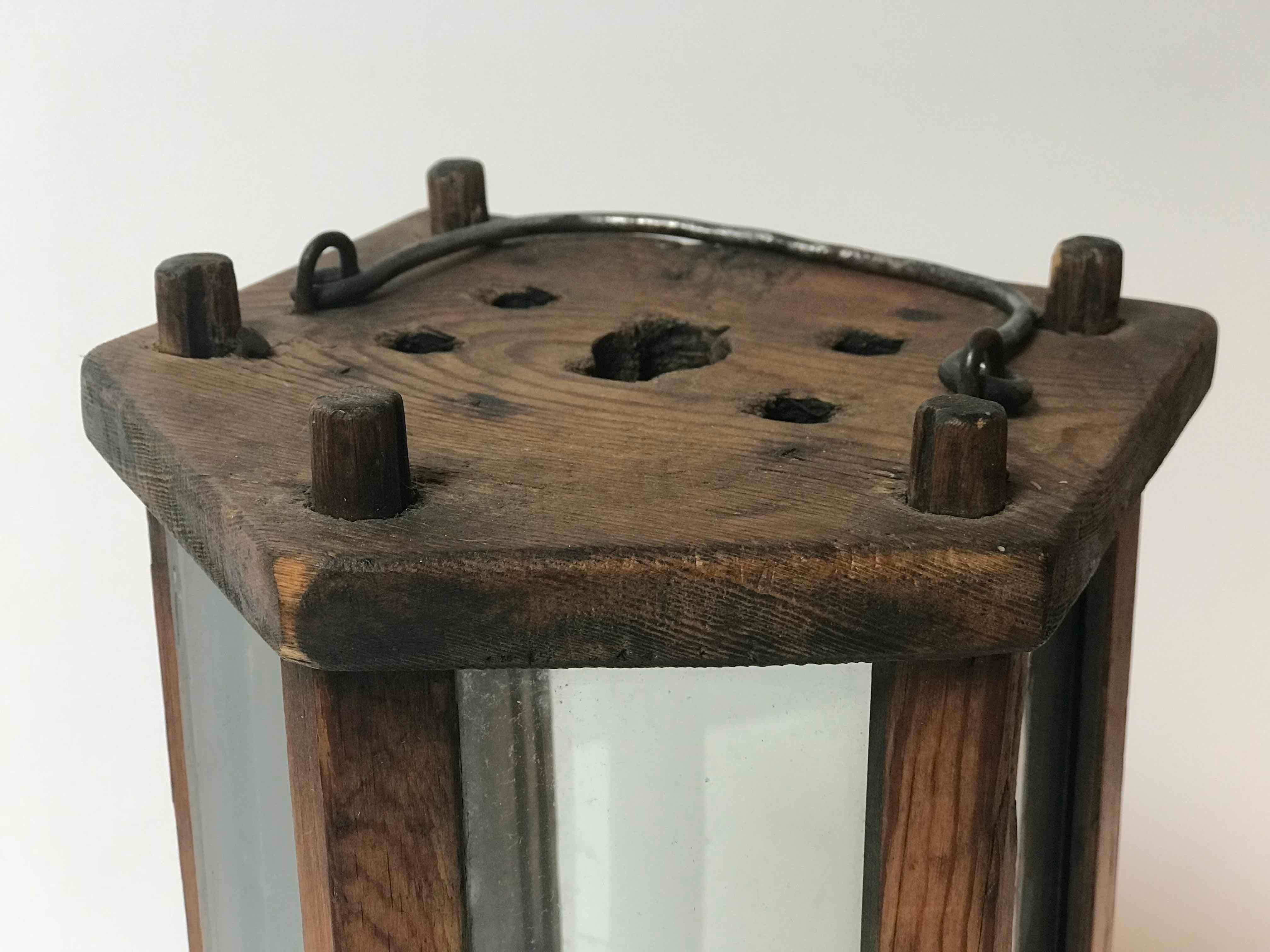 Swedish 19th-century five-sided wooden hurricane lantern or lamp with original glass siding and metal carrying handle. Notched pentagonal base holds a standard-sized taper. Rustic and understated, the patina here is exquisite—the wood aged to a