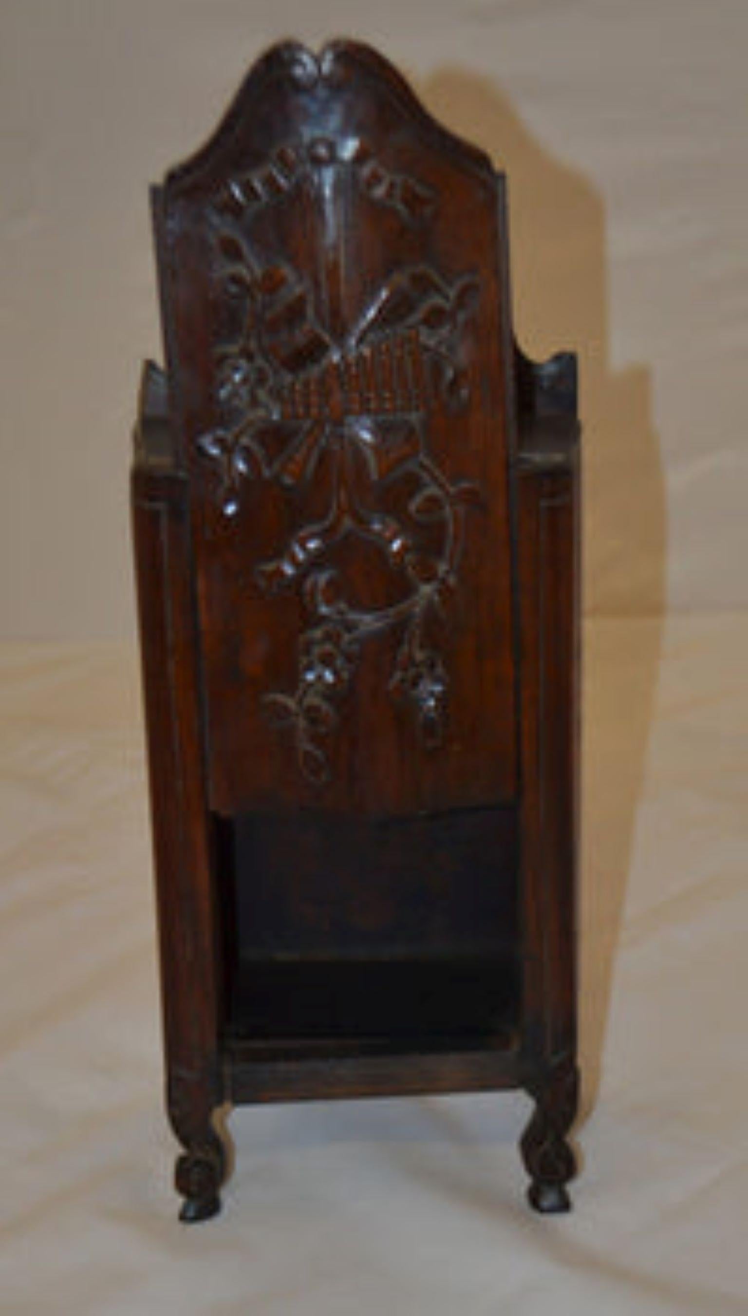Late 19th century salt box, with an intricate carved flower motif on the sliding door, resting on scroll feet with a top flower finial. 1880, 16.5