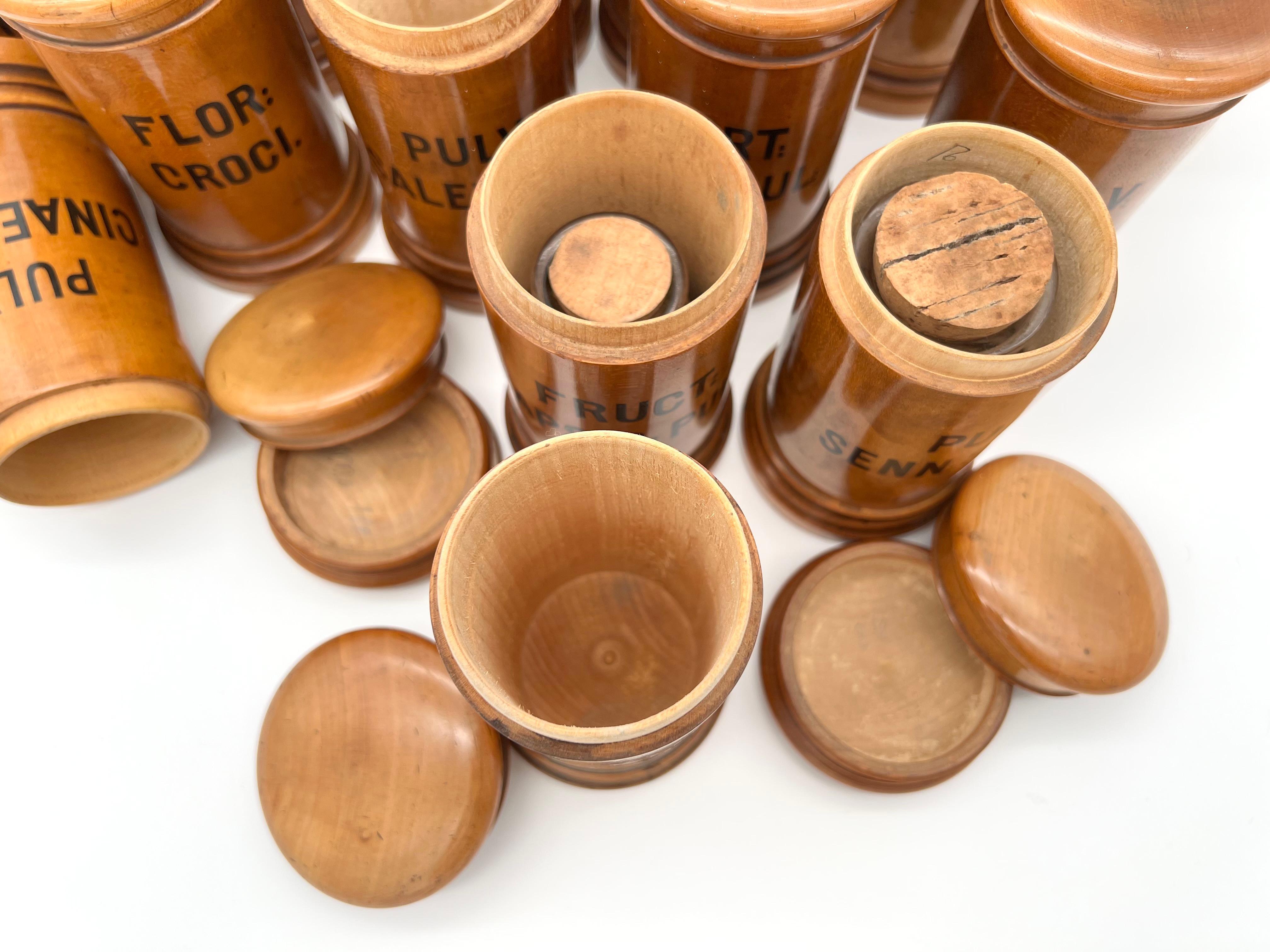 Hölzerne Wiener Apothekengefäße aus dem späten 19. Jahrhundert, in einem Satz von 22 Stück. 

Die Behälter mit Deckel sind aus Buchsbaumholz gefertigt und mit den lateinischen Namen der verschiedenen Gewürze bedruckt.

Sie sind im Allgemeinen in