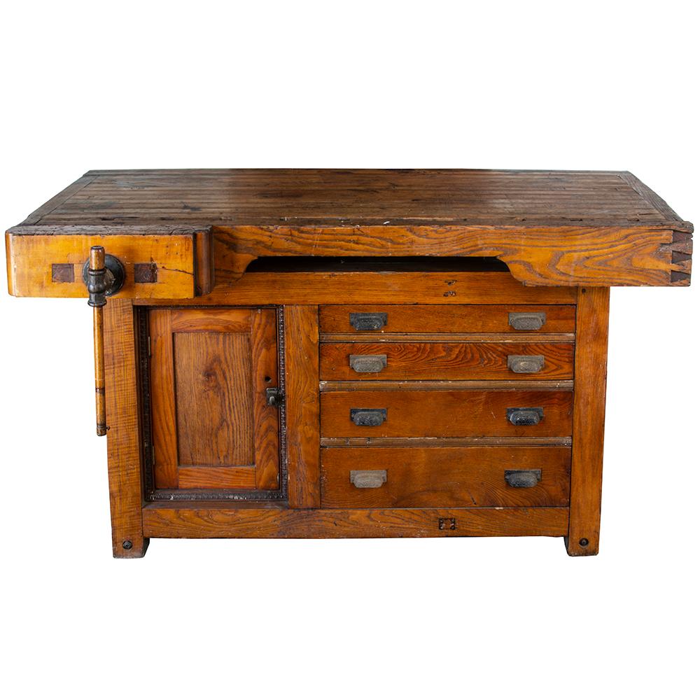 This beautiful solid ash and rock maple workbench is an excellent piece of late 19th century craftsmanship. The fully functional vise grip has a hand carved solid ash handle. The cabinetry is adorned with an egg and dart border and each drawer is