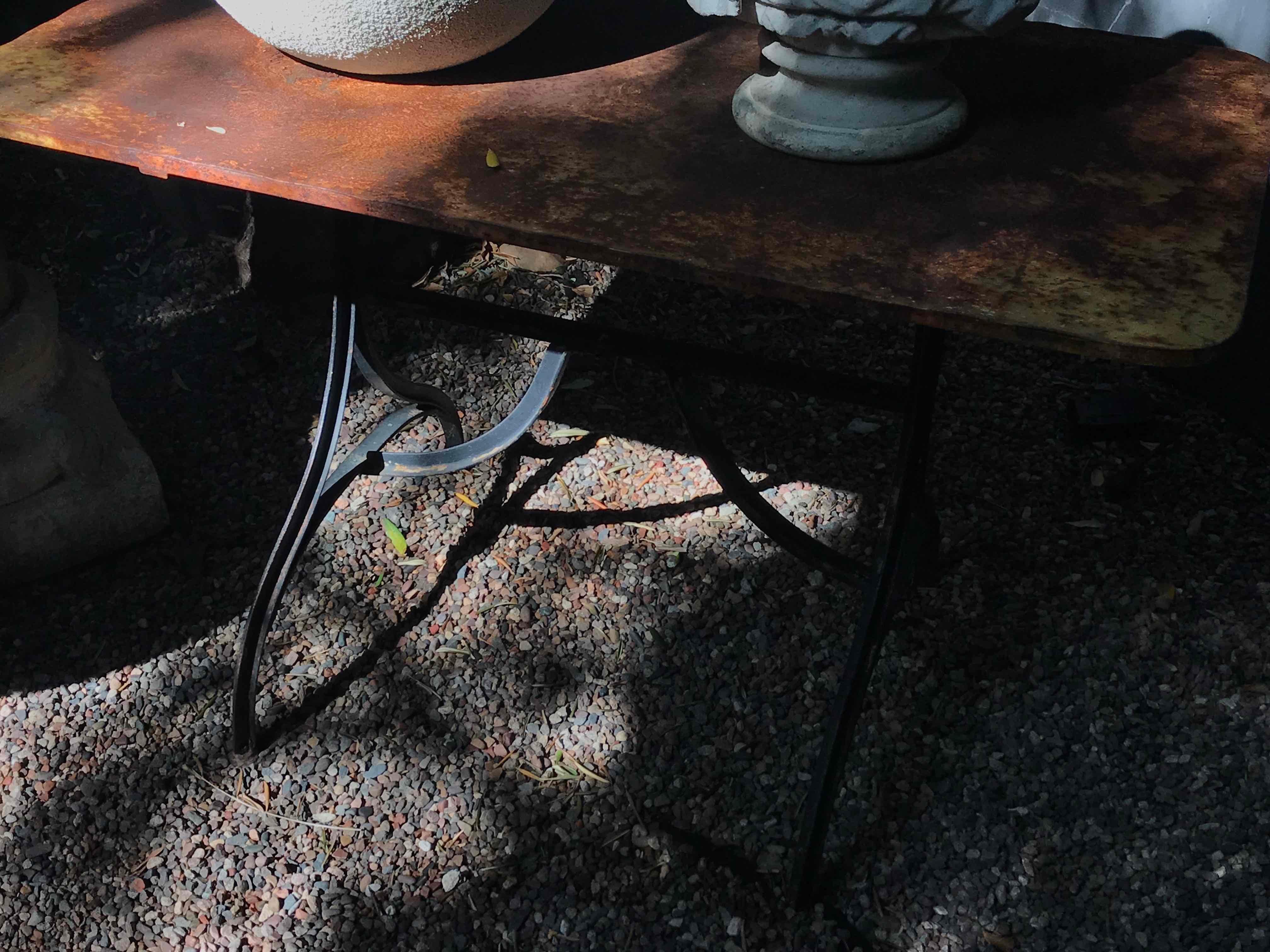 Late 19th century yellow garden table with natural patina on a iron trestle base from France.