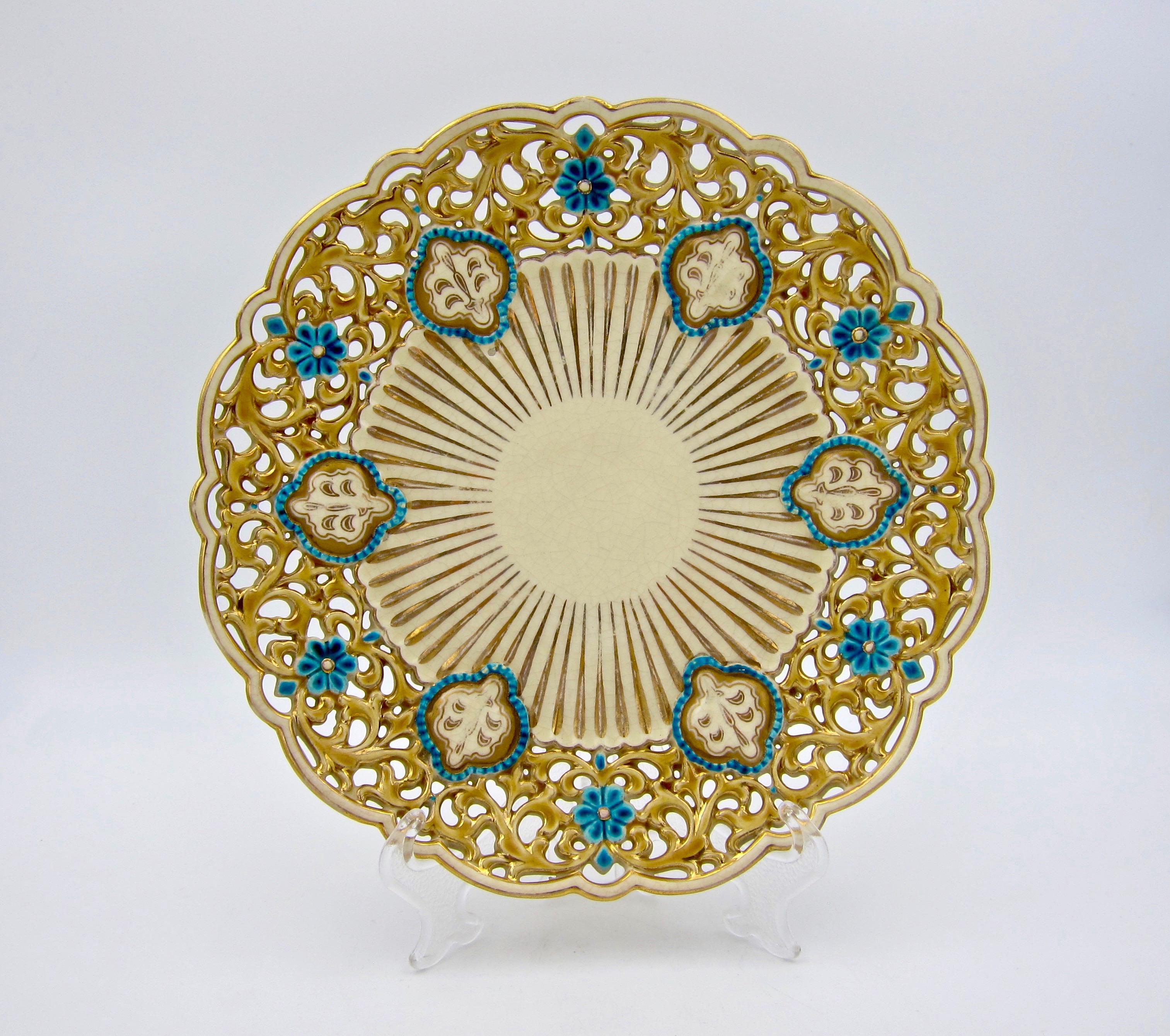 An antique ornamental cabinet plate / dish from Zsolnay Pecs of Hungary, dating circa 1880s. The faience plate is a fine example of late 19th century Victorian Eclecticism, featuring aspects of Zsolnay's Turko-Hungarian decor with gilt, gold, and