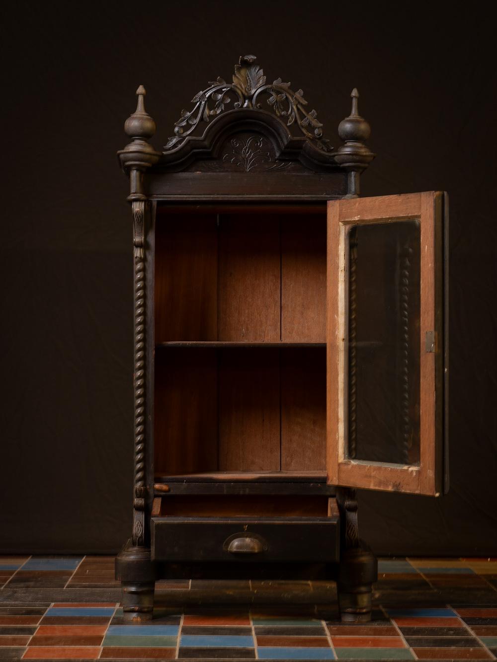 This Late 19th / early 20th century Antique wooden Temple cabinet
  is a stunning testament to the rich spiritual and artistic heritage of Burma. Crafted from wood and standing at a height of 126 cm, with dimensions of 58.5 cm in width and 40 cm in