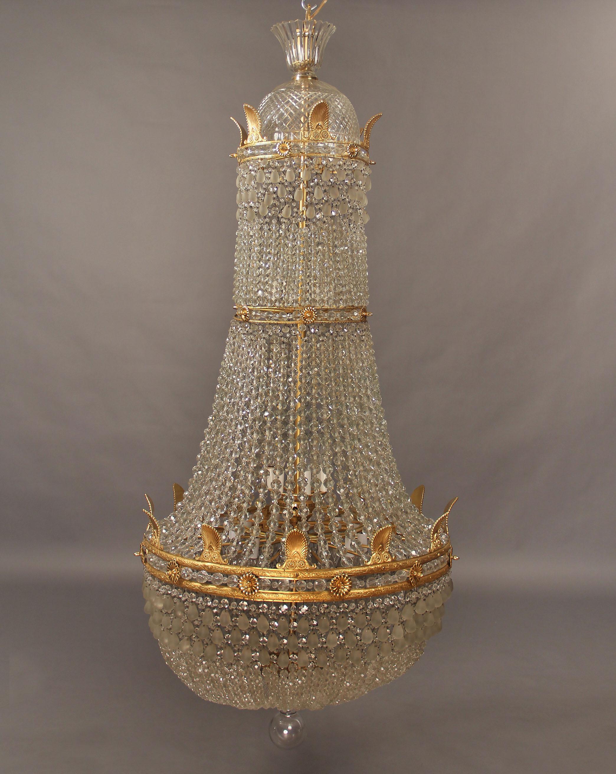 An Important Late 19th/Early 20th Century gilt bronze and beaded twenty four light Empire Style basket chandelier

With a crystal dome crown and bronze empire designs, twenty four tiered interior lights.
 
