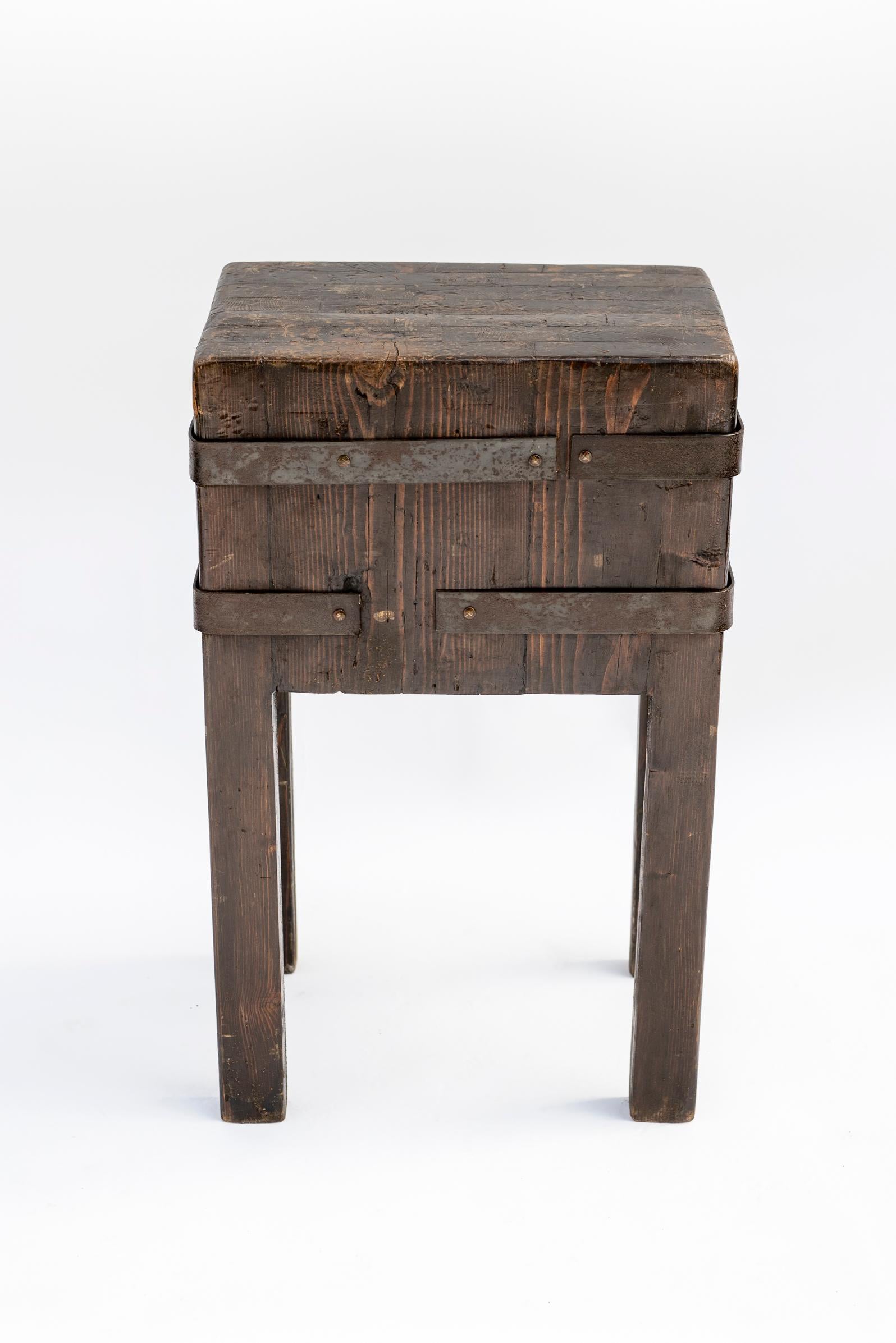 Table de boucher en pin massif avec bandes en fer forgé, datant de la fin du 19e ou du début du 20e siècle. Le plateau épais présente une surface magnifiquement usée et patinée par des années d'utilisation. Soutenue par des pieds droits renforcés