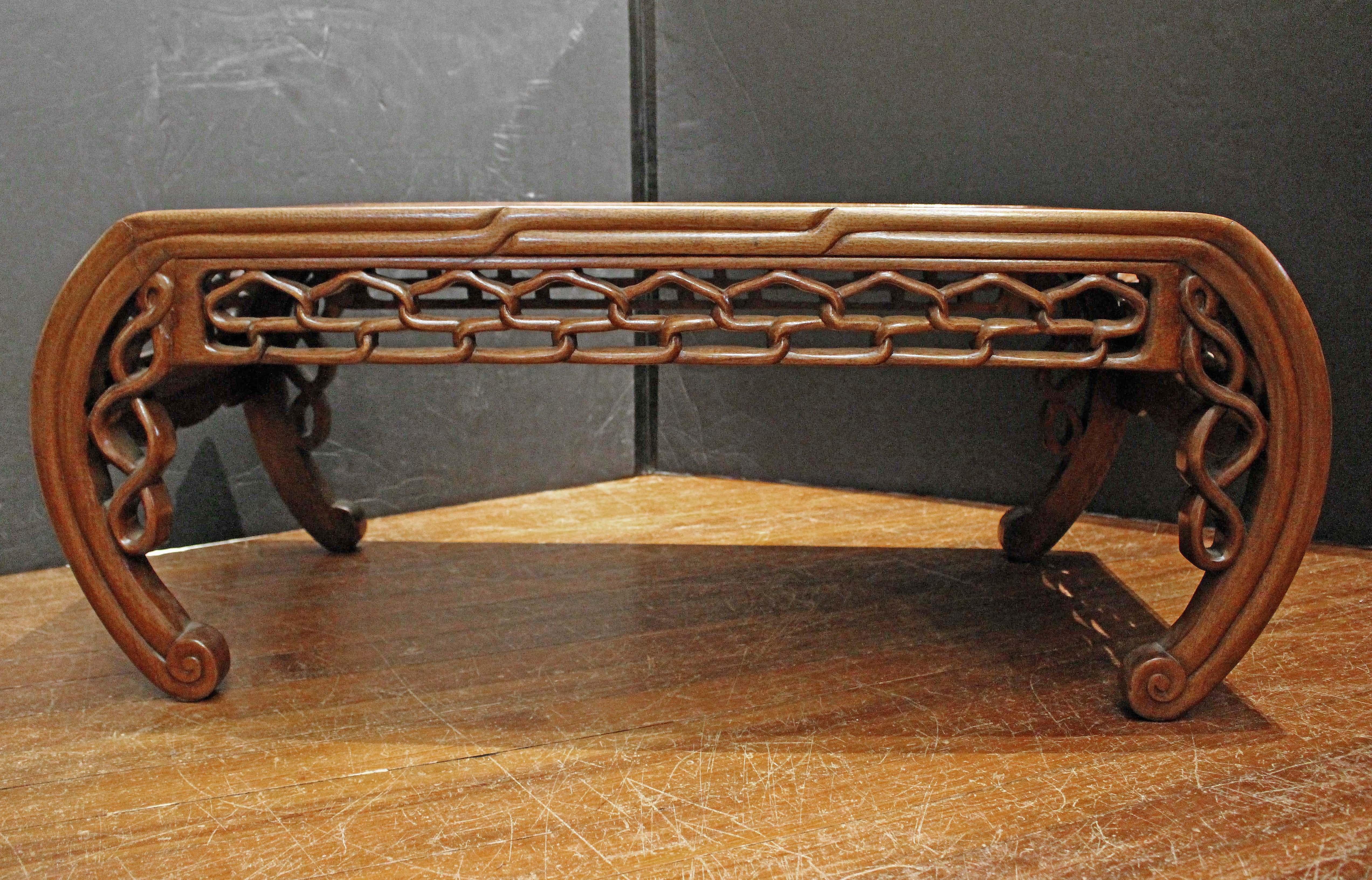 Mesa de centro baja de opio chino de finales del siglo XIX-principios del XX. Forma Kang; teca. El cuerpo orgánico con patas incurvadas sostiene un tablero panelado. Los delantales de eslabones tallados son especialmente agradables. Elegante