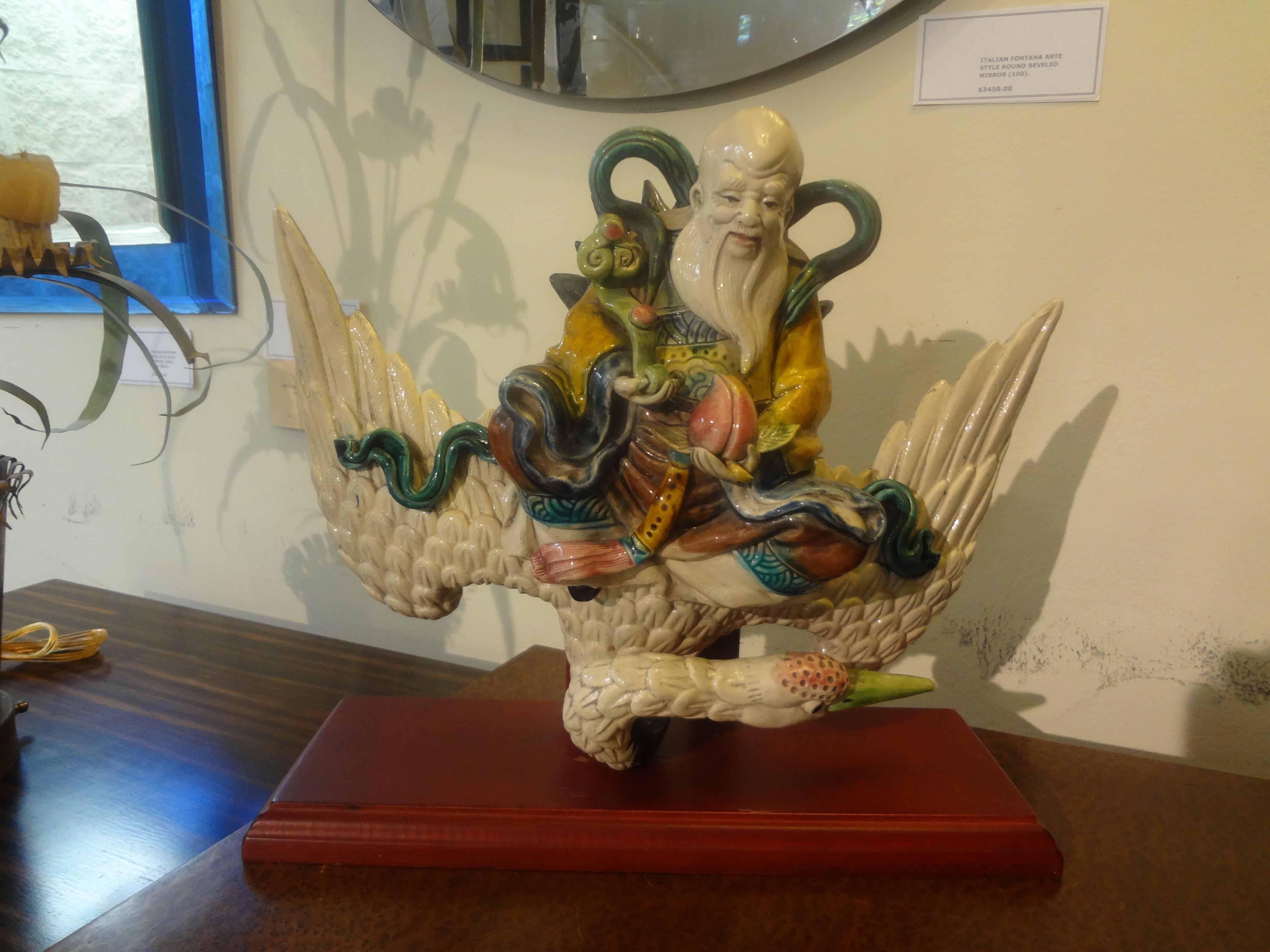 Late 19th-Early 20th Century Chinese Roof Tile.
Our lovely antique Chinese glazed pottery or porcelain roof tile depicts a warrior riding on a Phoenix bird. This piece is signed and  mounted on a custom wood stand.
Gorgeous!