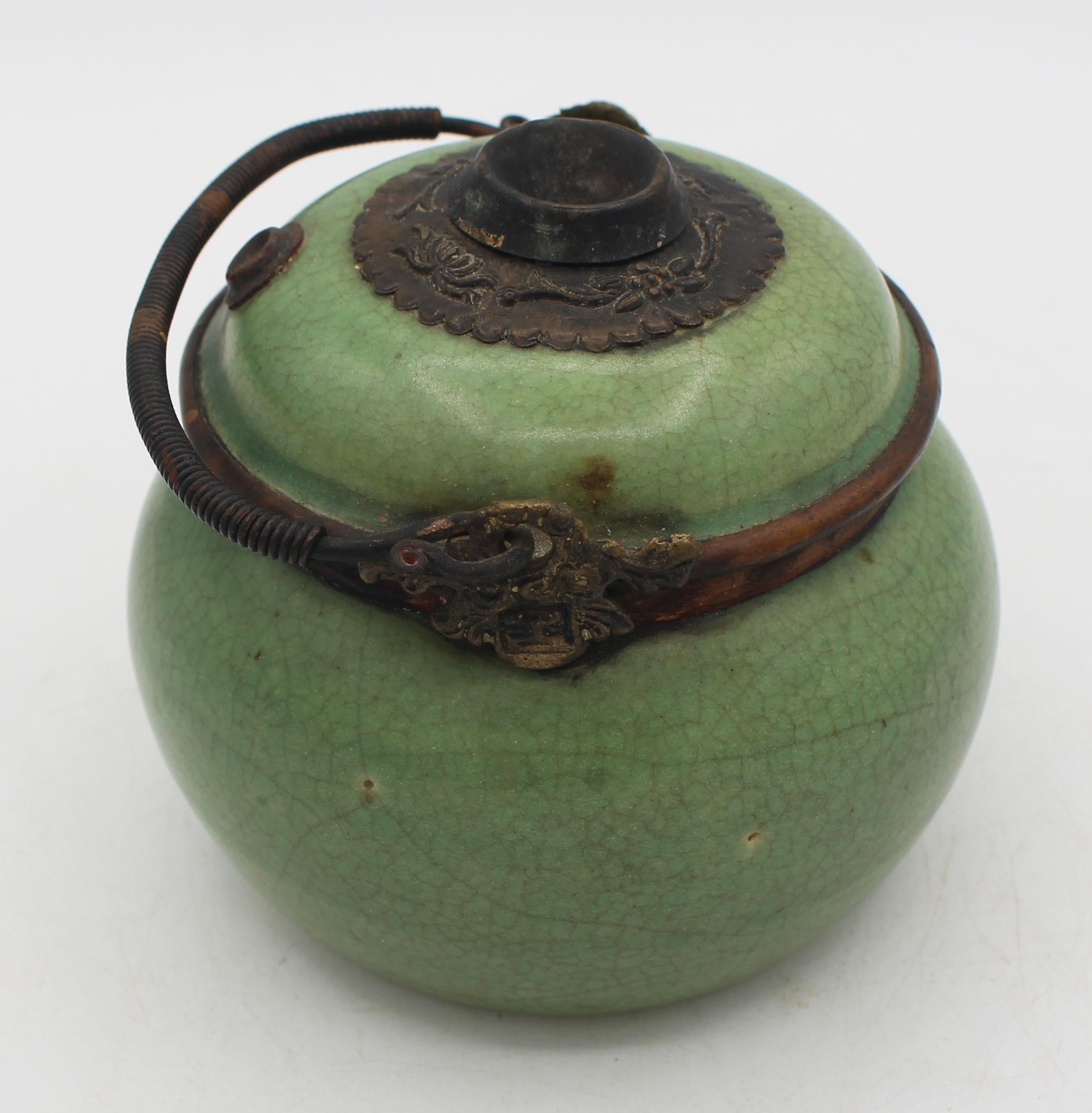 Late 19th-early 20th century Chinese stoneware opium water pot. Crackle glazed stoneware, celadon color, mounted with cast brass & copper fittings. Complete. Qing dynasty. Probably made for export to Vietnam.
4.75