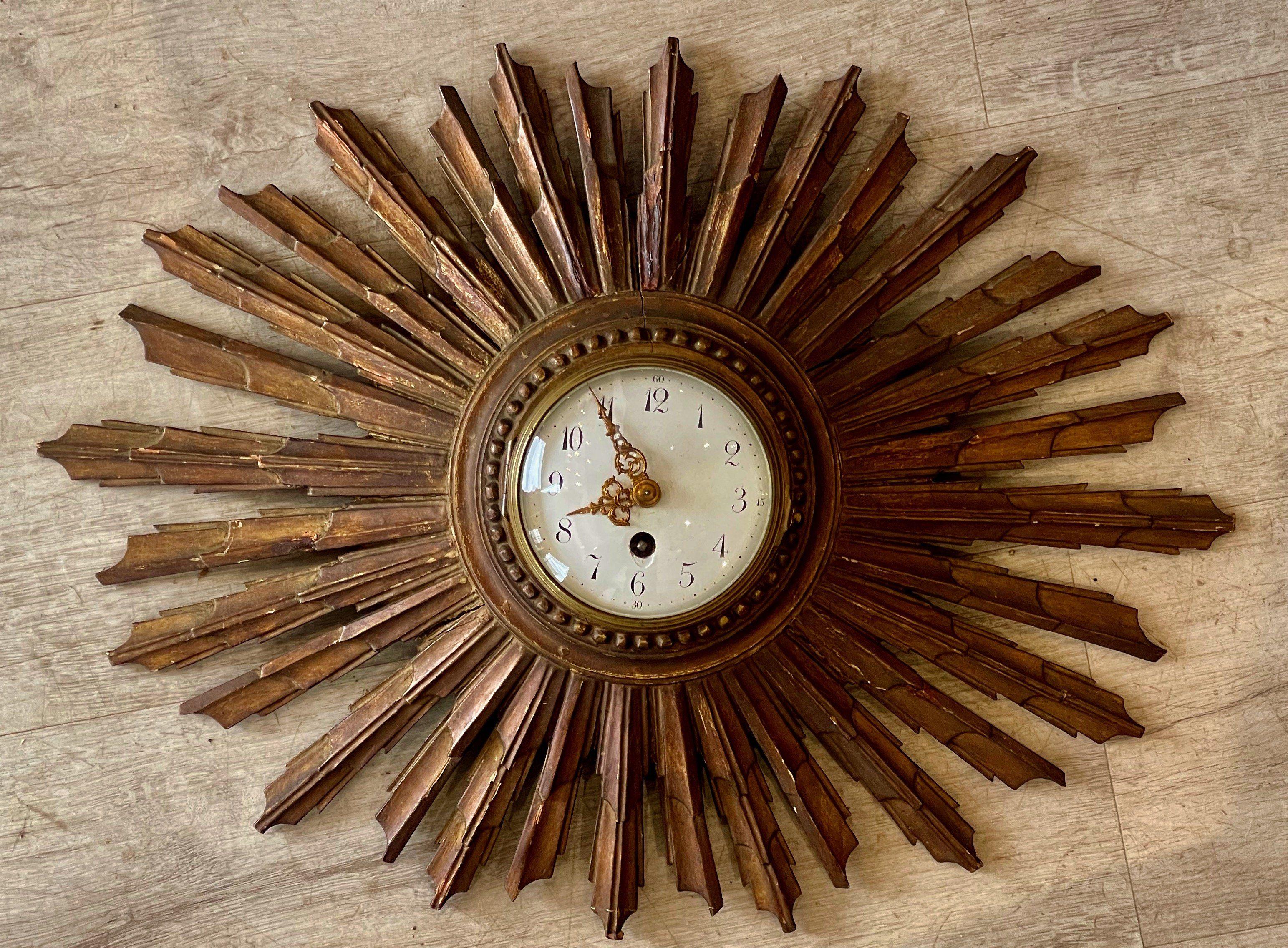 Late 19th-early 20th century French sunburst clock, the carved rays surrounding a beaded circle encasing an enamel-faced clock having fine gilt hands. In working condition.