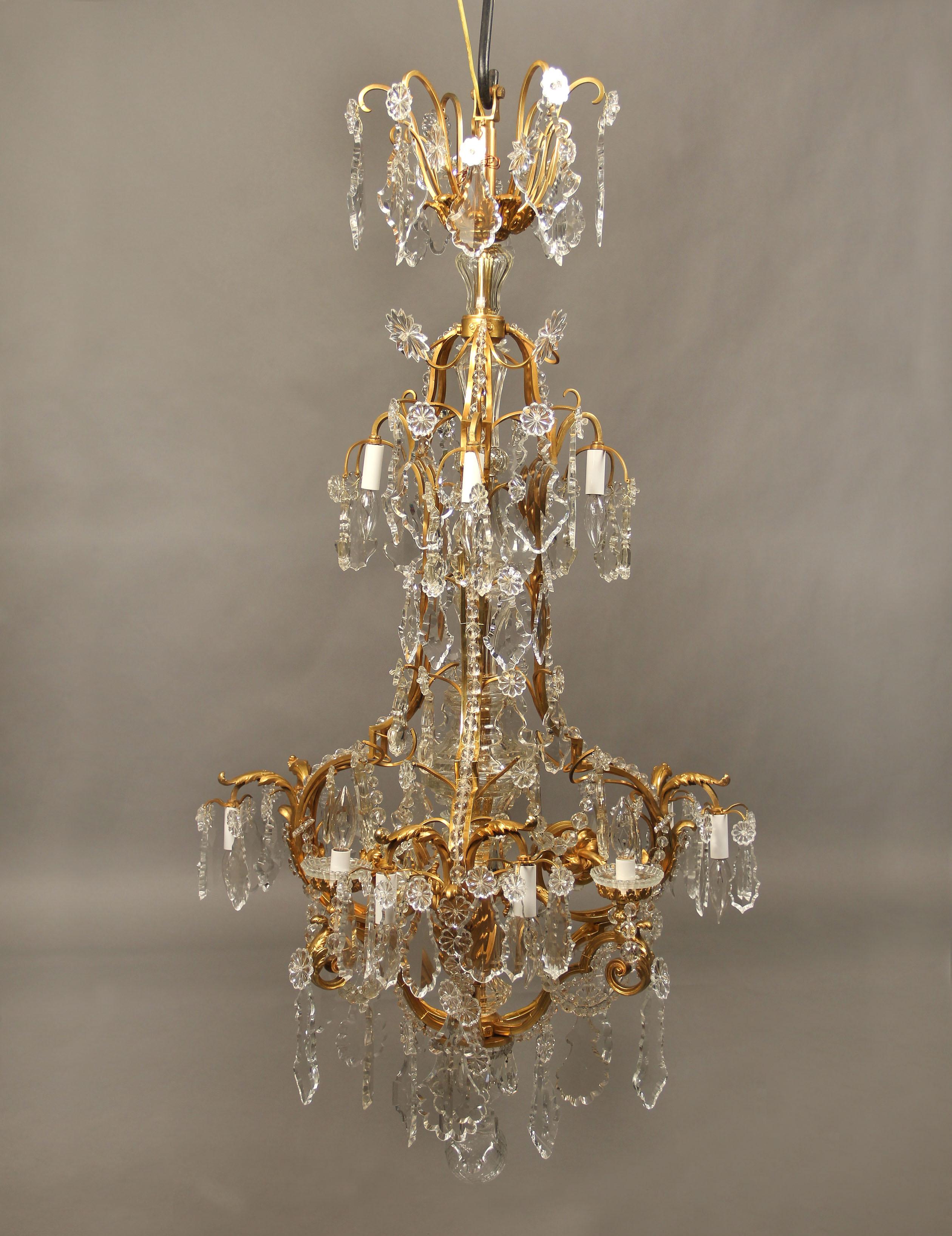 A beautiful late 19th-early 20th century gilt bronze and baccarat crystal twelve-light chandelier

Multi-faceted and shaped crystal, cut crystal central column, beaded arms, twelve perimeter lights, bobeche cups.