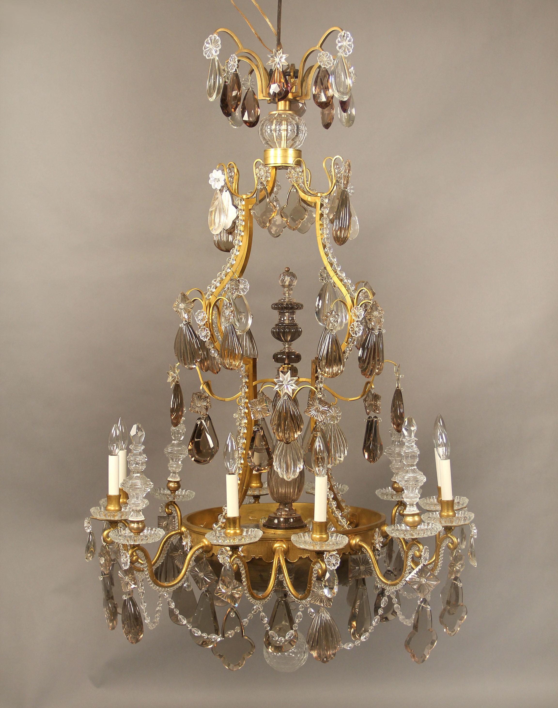 A very special late 19th-early 20th century gilt bronze and Baccarat crystal sixteen-light chandelier.

Multifaceted and shaped crystals, some tinted. Beaded arms, crystal central finial, four spears, eight interior and eight perimeter lights,