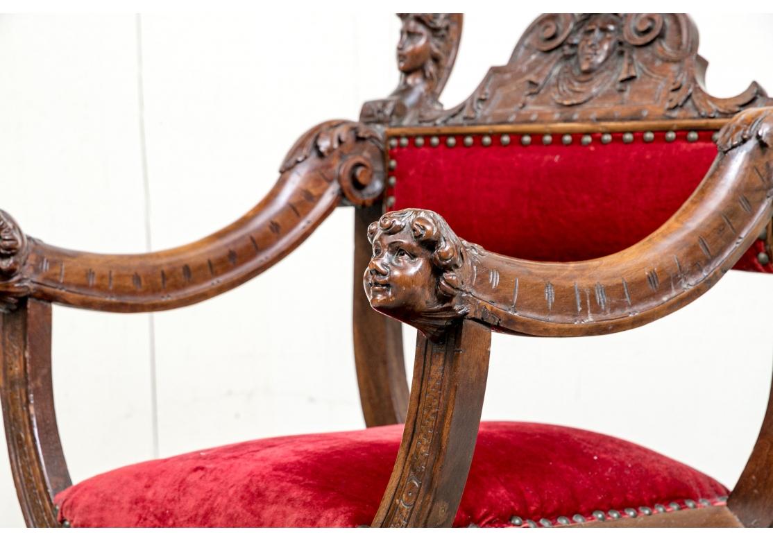 A particularly noteworthy Savonarola chair with deft carving and vibrant and colorful custom seat and back fabric.  Late 19th century/early 20th century Renaissance style Savonarola walnut arm chair. The chair with curule styling, carved classical