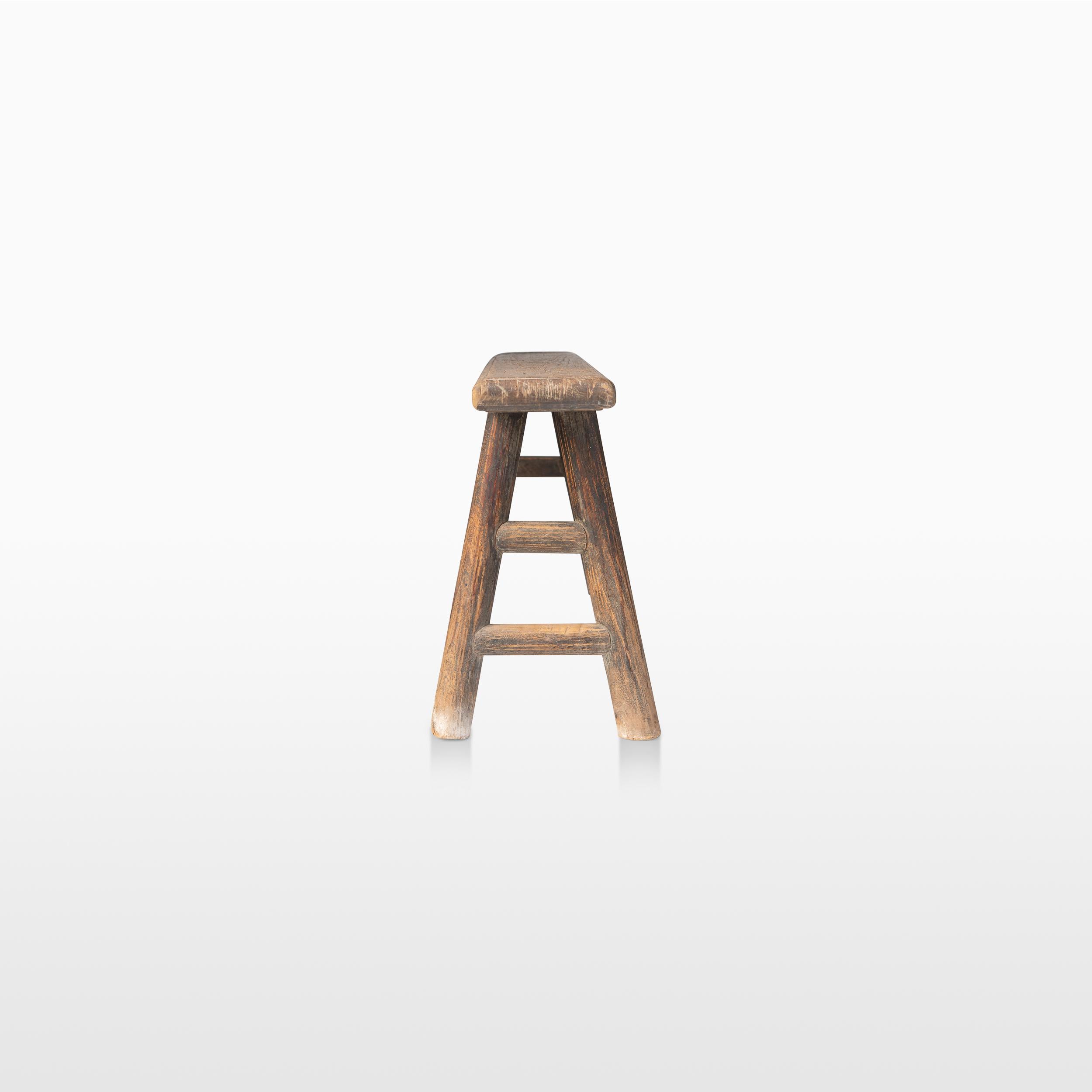 Ce banc rustique en bois de la fin du XIXe siècle ou du début du XXe siècle provient probablement du nord de la Chine.  Ce banc primitif en bois ou cette table console étroite a un plateau en planches simples et des pieds évasés en angle. Le cadre