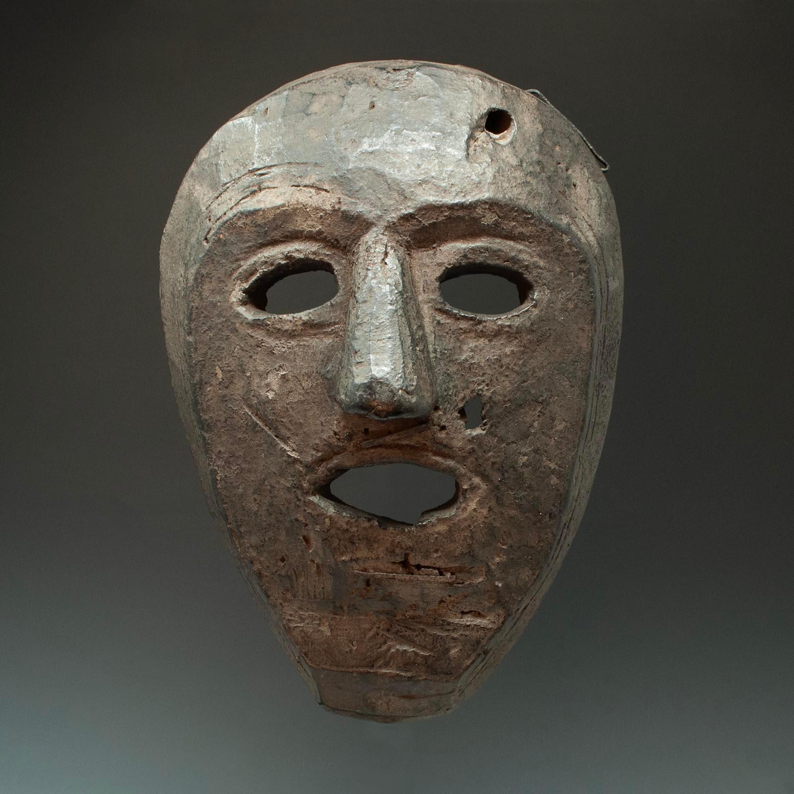 Stammesmaske, spätes 19. - frühes 20. Jahrhundert, Westnepal

Eine Maske aus West-Nepal mit einer eher herzförmigen Gesichtsfläche. Es gibt drei große eiserne Klammern, von denen zwei möglicherweise Fell oder Haare befestigt haben. Die Rückseite