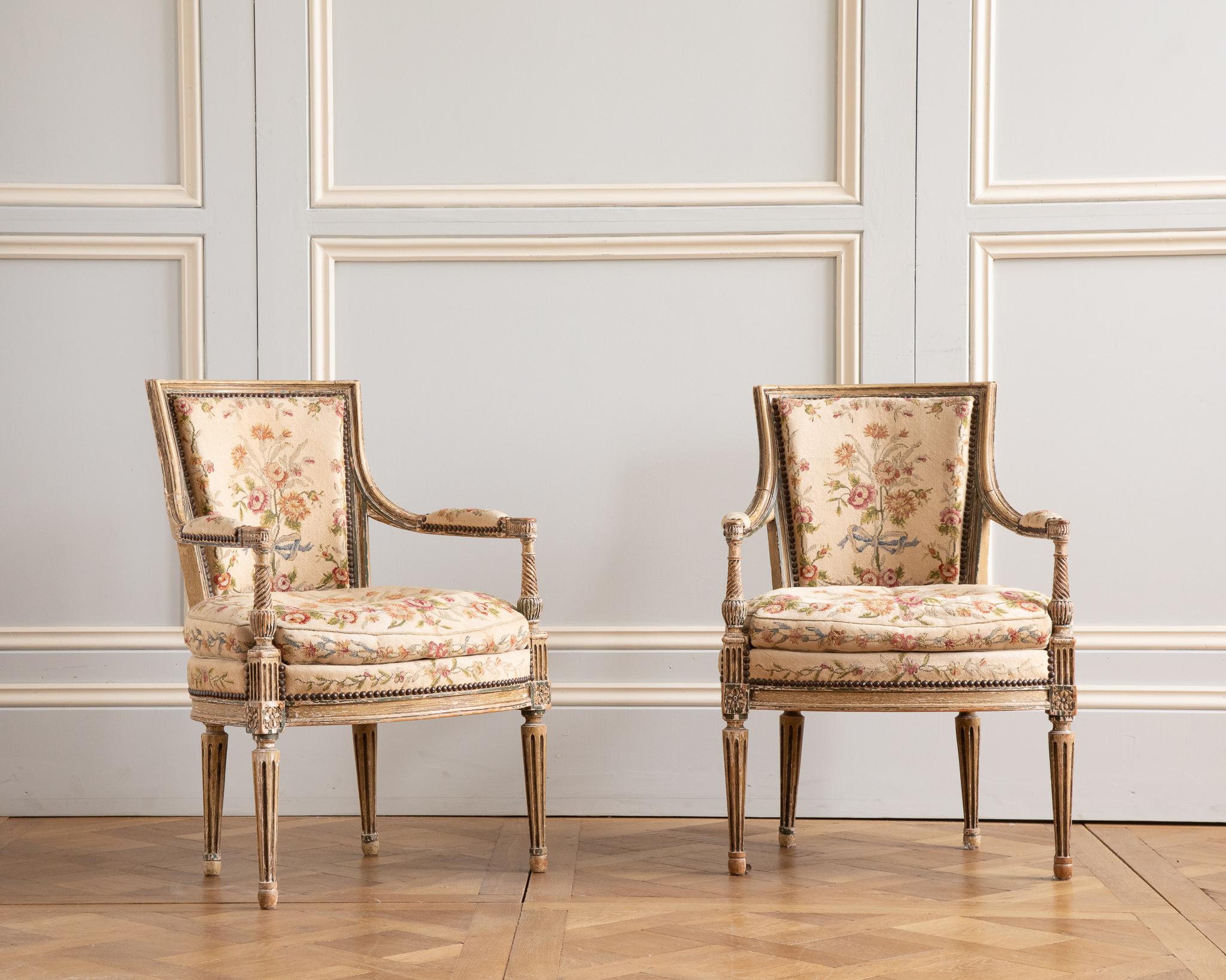 A late 19th century pair of Armchairs Painted in two tones of French green and cream with an original patina.
with tapered and fluted legs
They are both upholstered with a Floral Needlepoint fabric.

