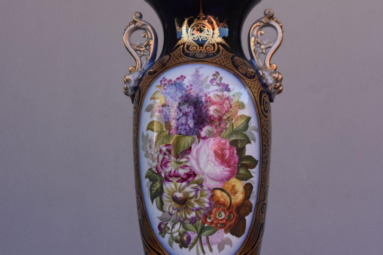 Vase à anse peint en porcelaine de Bayeux avec des roses, des dahlias, des anémones, des boutons d'or, des lilas et d'autres fleurs.